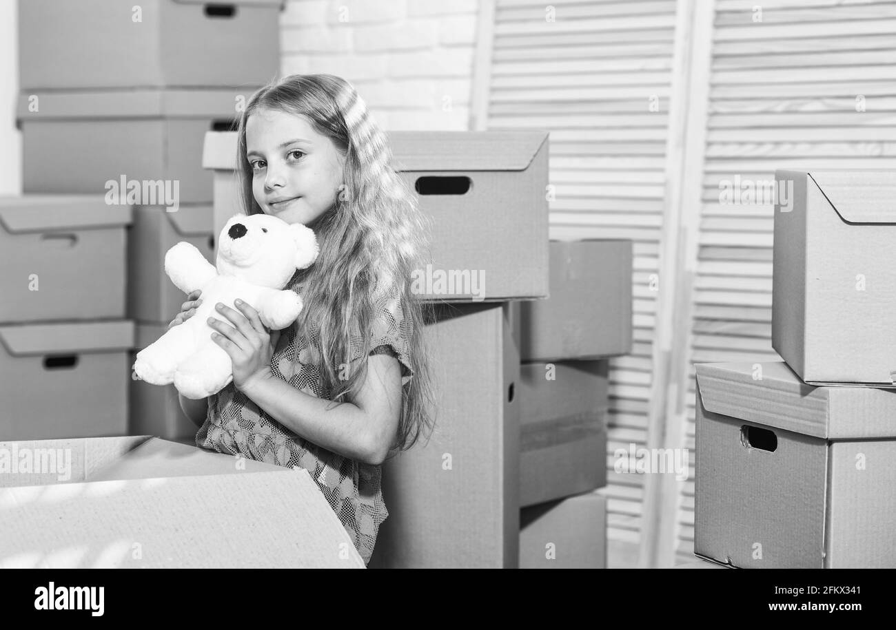 Entusiasta di una nuova casa. Ragazza bambino giocare con il giocattolo vicino scatole. Passare al concetto. Preparatevi al movimento. In movimento. Imballaggio. Affitto casa. Famiglia Foto Stock