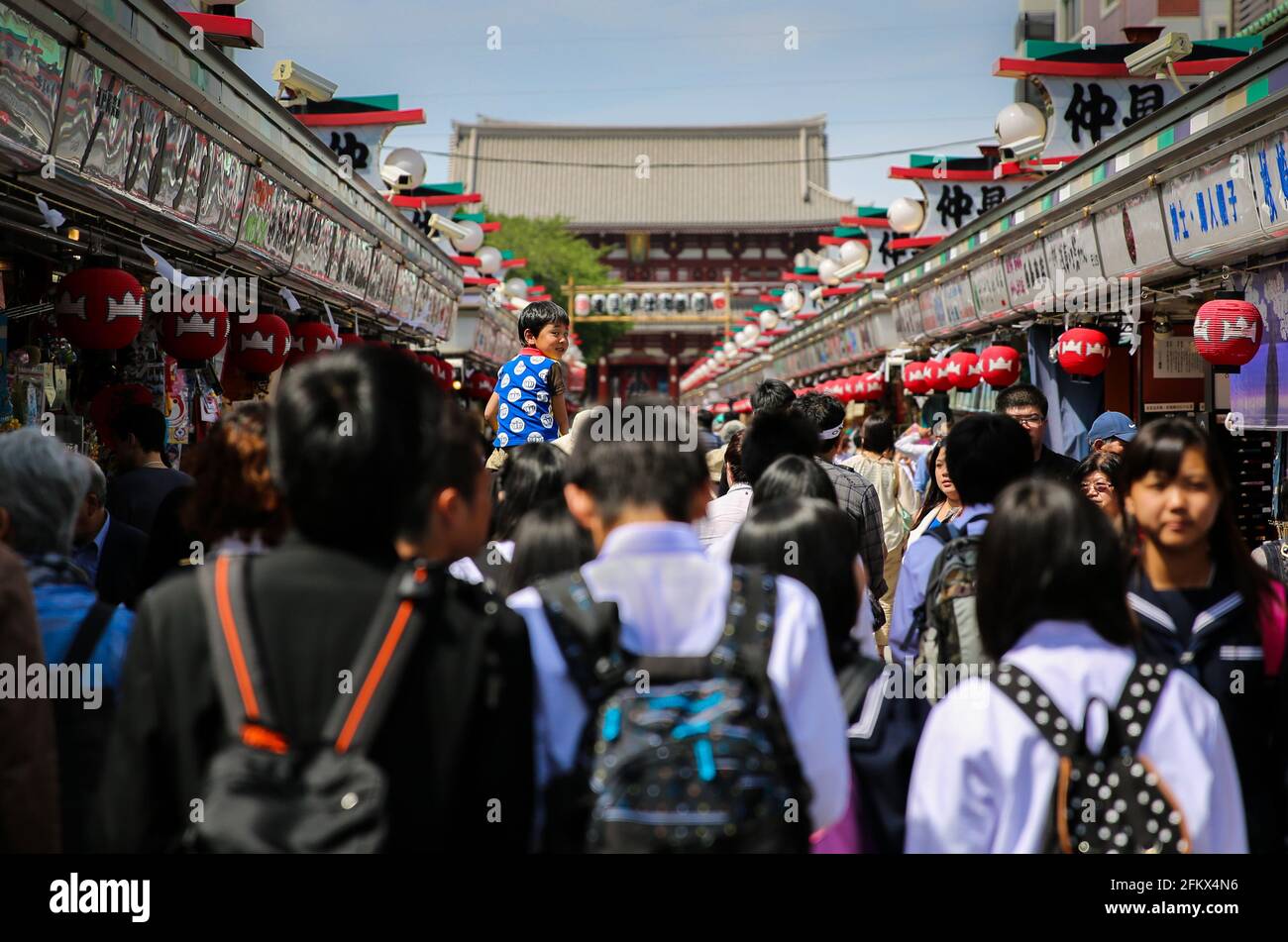 Affollate folle di turisti e bambini delle scuole giapponesi che camminano lungo la via dello Shopping di Nakamise al Tempio di Sensoji, Asakusa. Tokyo, Giappone. Foto Stock