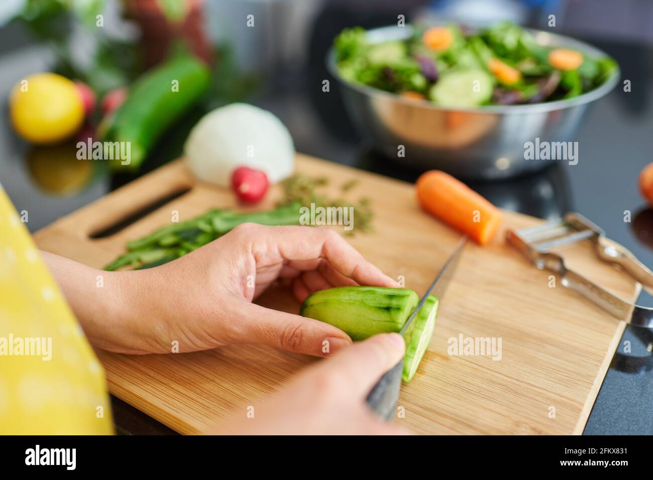 Primo piano di un coltello che taglia un cetriolo. Foto di alta qualità. Foto Stock