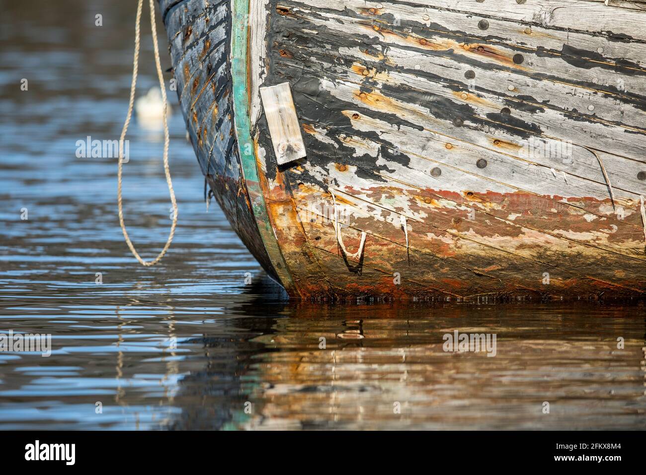 Vecchia barca di pesca in legno in acqua, ha bisogno di pittura Foto Stock
