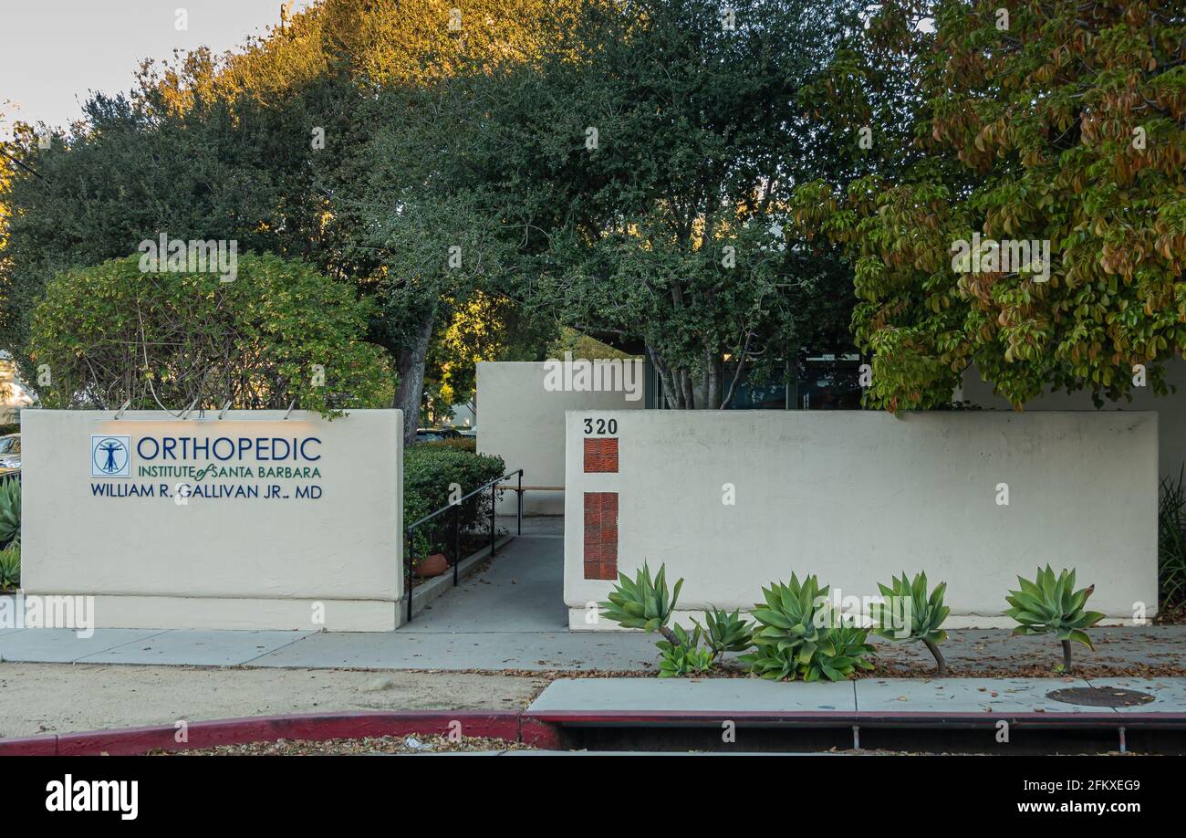Santa Barbara, CA, USA - 22 febbraio 2021: Primo mattino luce sulla facciata anteriore e l'ingresso dell'Istituto Ortopedico. Pareti beige, verde fogliame e d Foto Stock