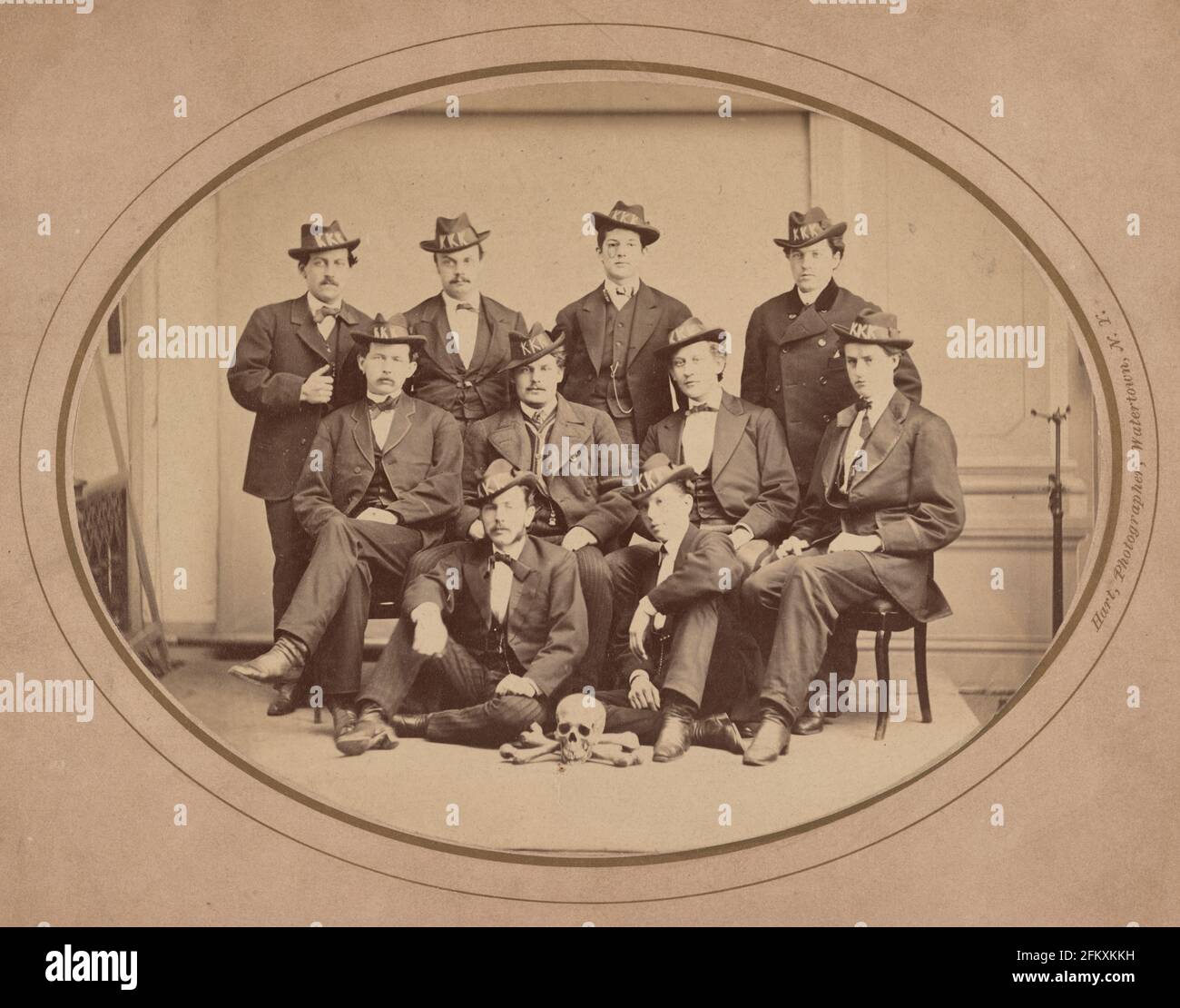 KU Klux Klan, Watertown Division 289 - la fotografia mostra dieci uomini posti seduti e in piedi, indossando cappelli con 'KKK' in grandi lettere, e con un cranio e ossa disposti sul pavimento di fronte a loro, circa 1870 Foto Stock
