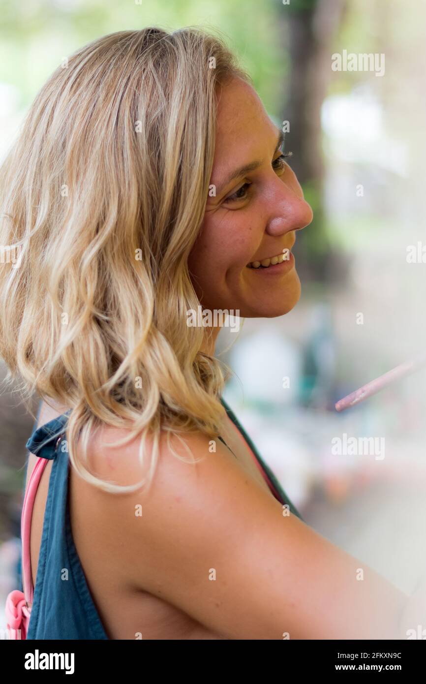 Vista laterale dell'artista femminile sorridente Foto Stock