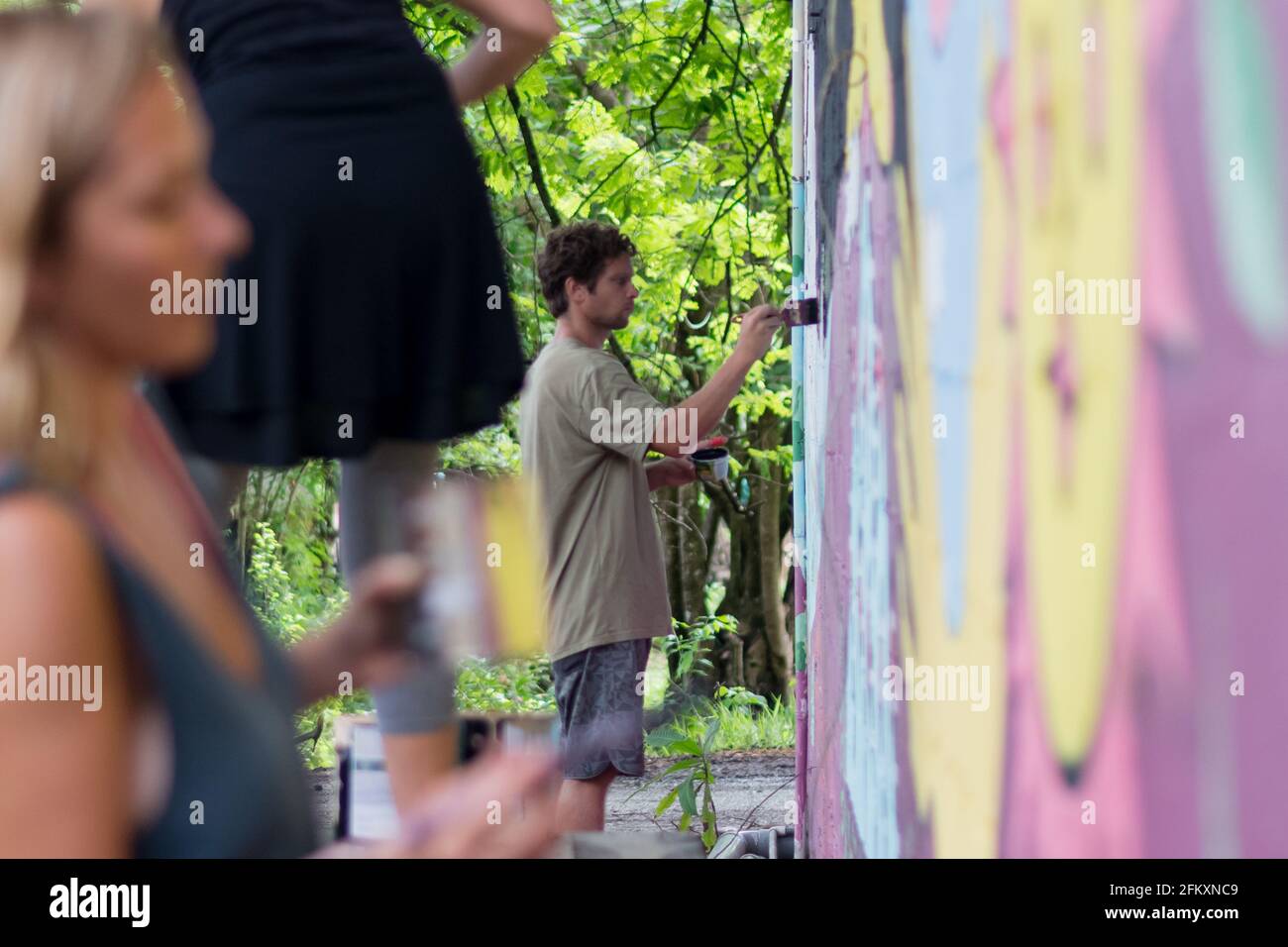 Artisti che dipingano un muro murale Foto Stock
