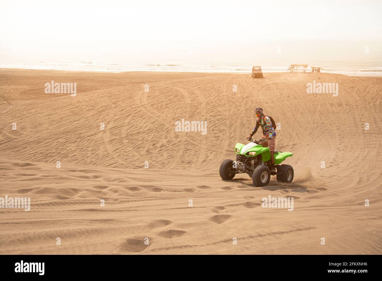 Uomo a cavallo di una moto quad su una duna di sabbia Una spiaggia messicana (Chachalacas) Foto Stock