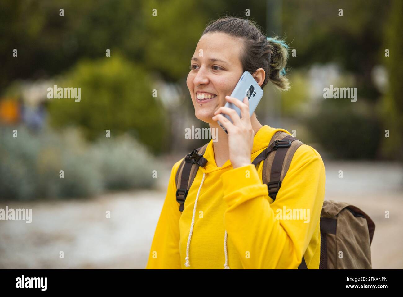Studente spagnolo che parla al telefono mentre cammina per l'università Foto Stock