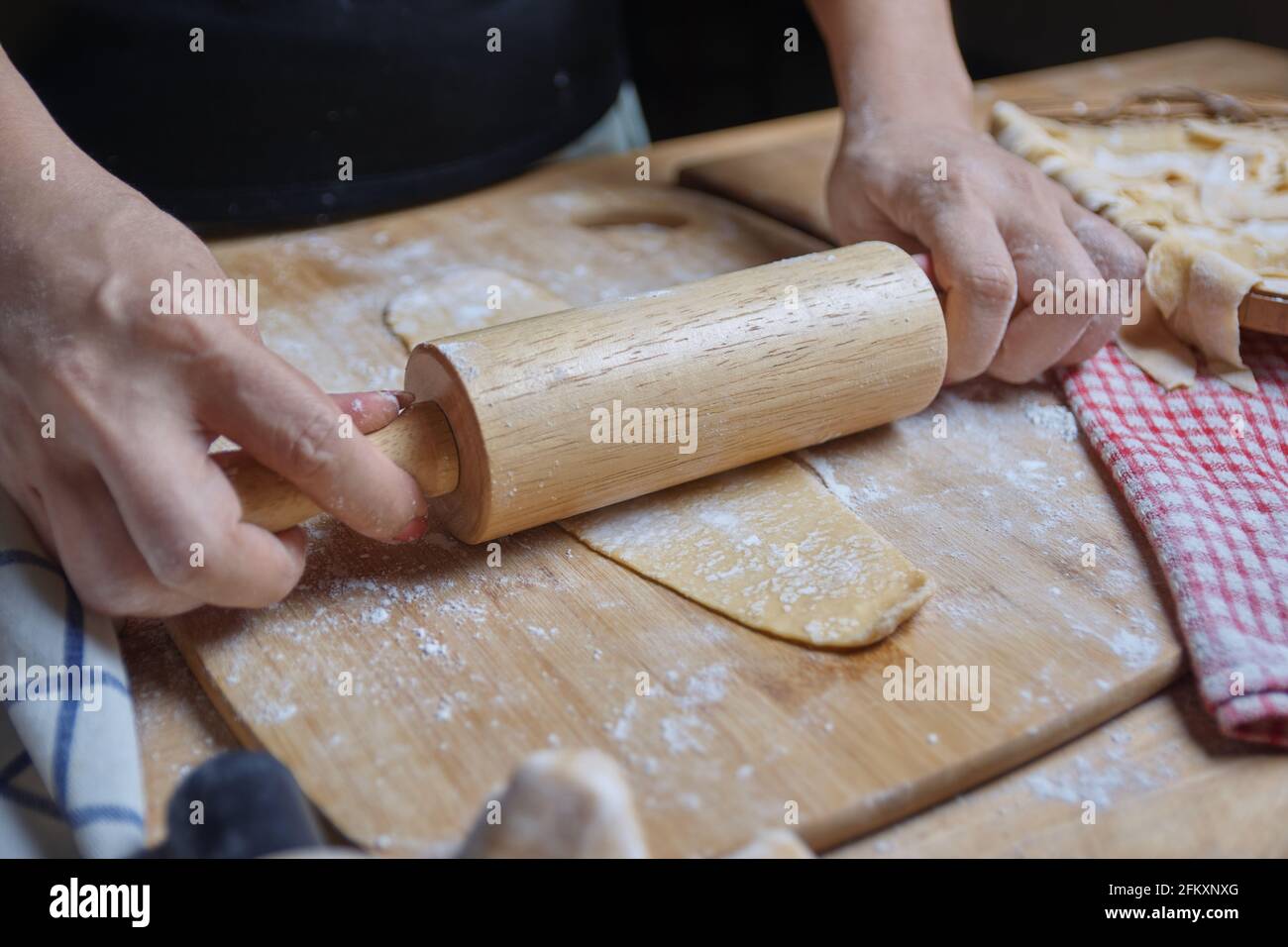 Vista ravvicinata di una donna che impastava l'impasto con un perno di rotolamento Foto Stock