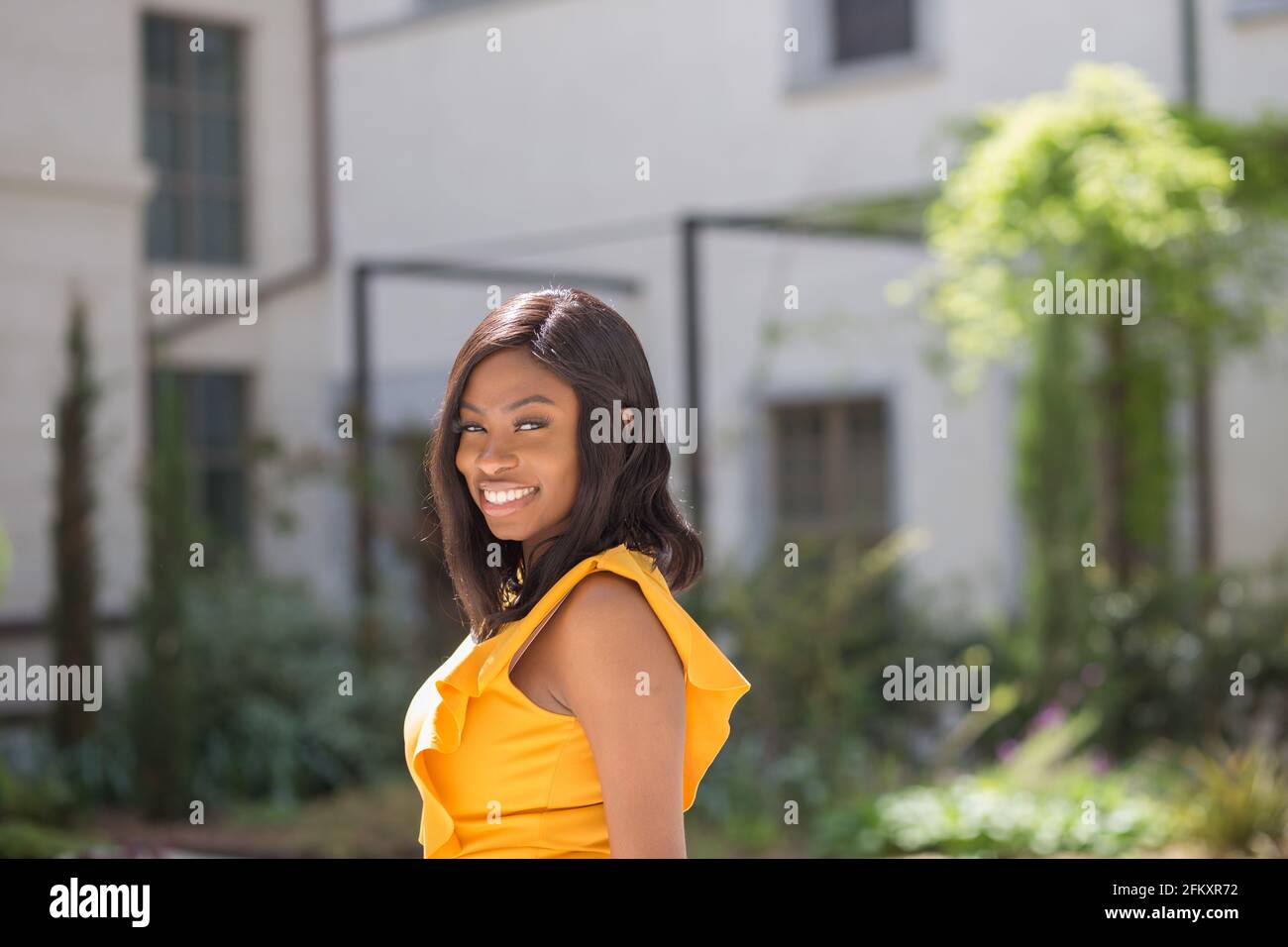 ritratto di giovane donna afro per le strade di lione francia. abito giallo. Foto Stock