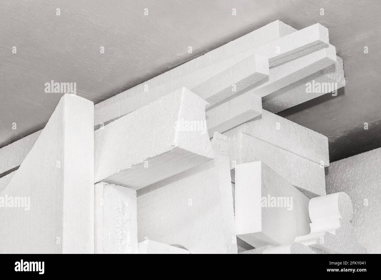 Una pila di materiale espanso industriale in polistirene bianco immagazzinato in magazzino. Foto Stock
