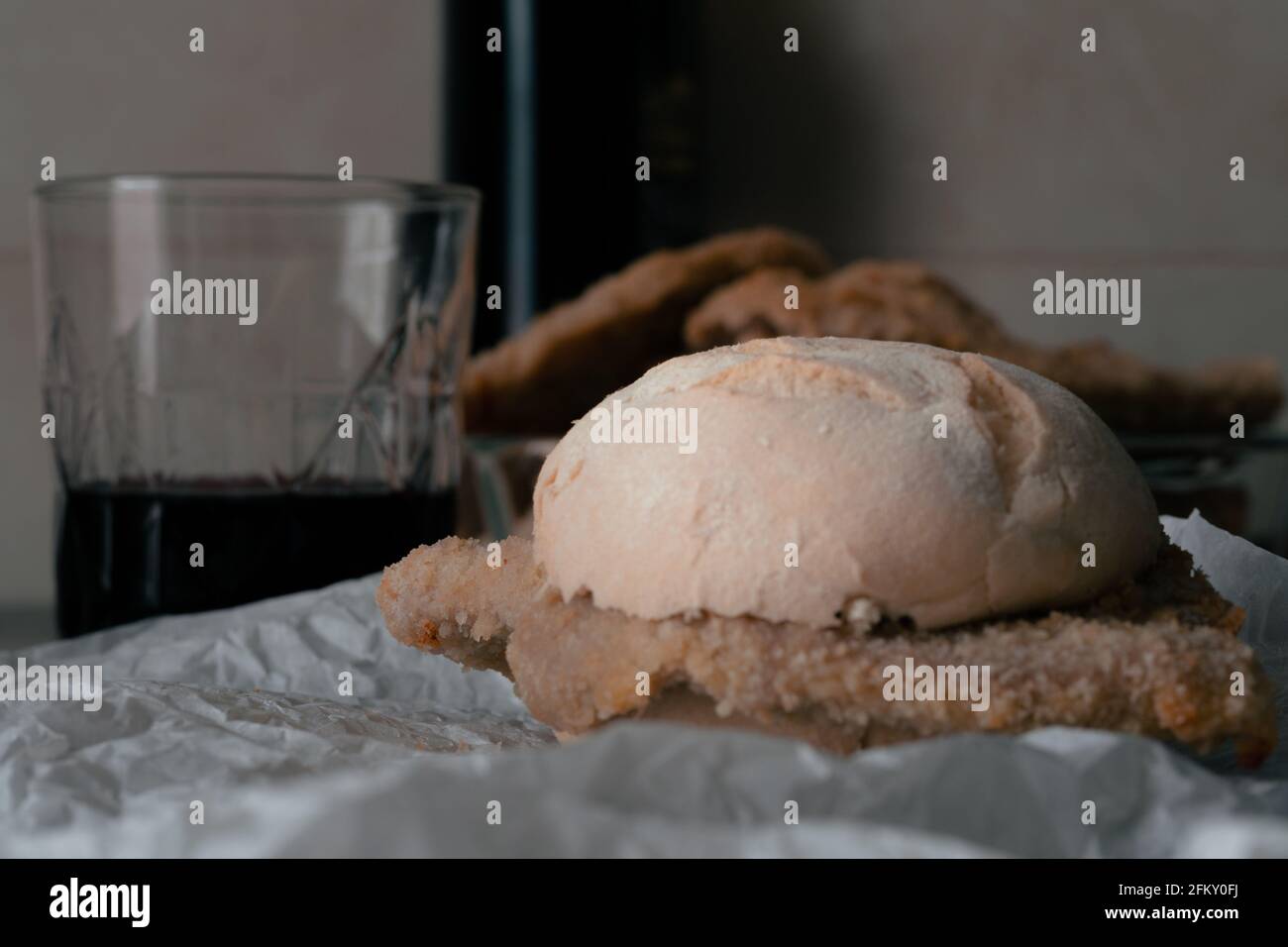 Come un veloce meeal un sandwich di stile milanese cotoletta con bicchiere di vino rosso Foto Stock