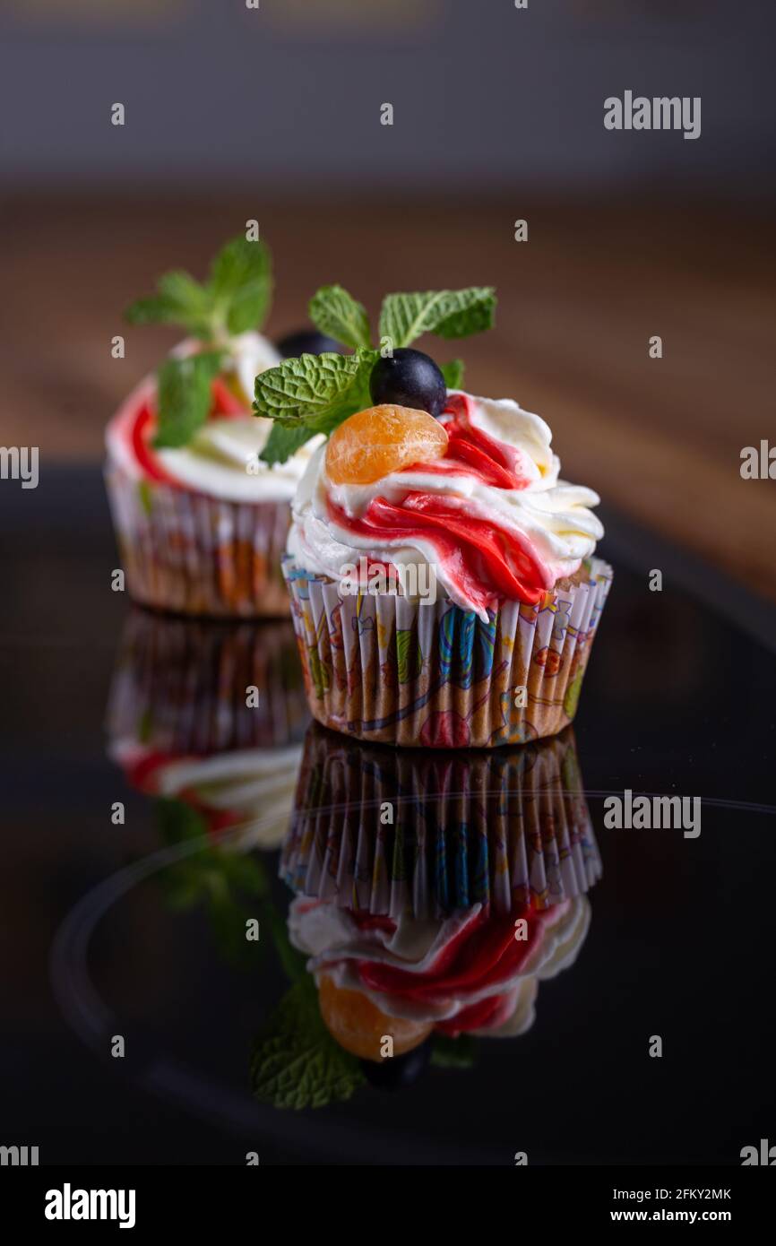 cupcake con frutti di bosco freschi e primo piano di menta Foto Stock