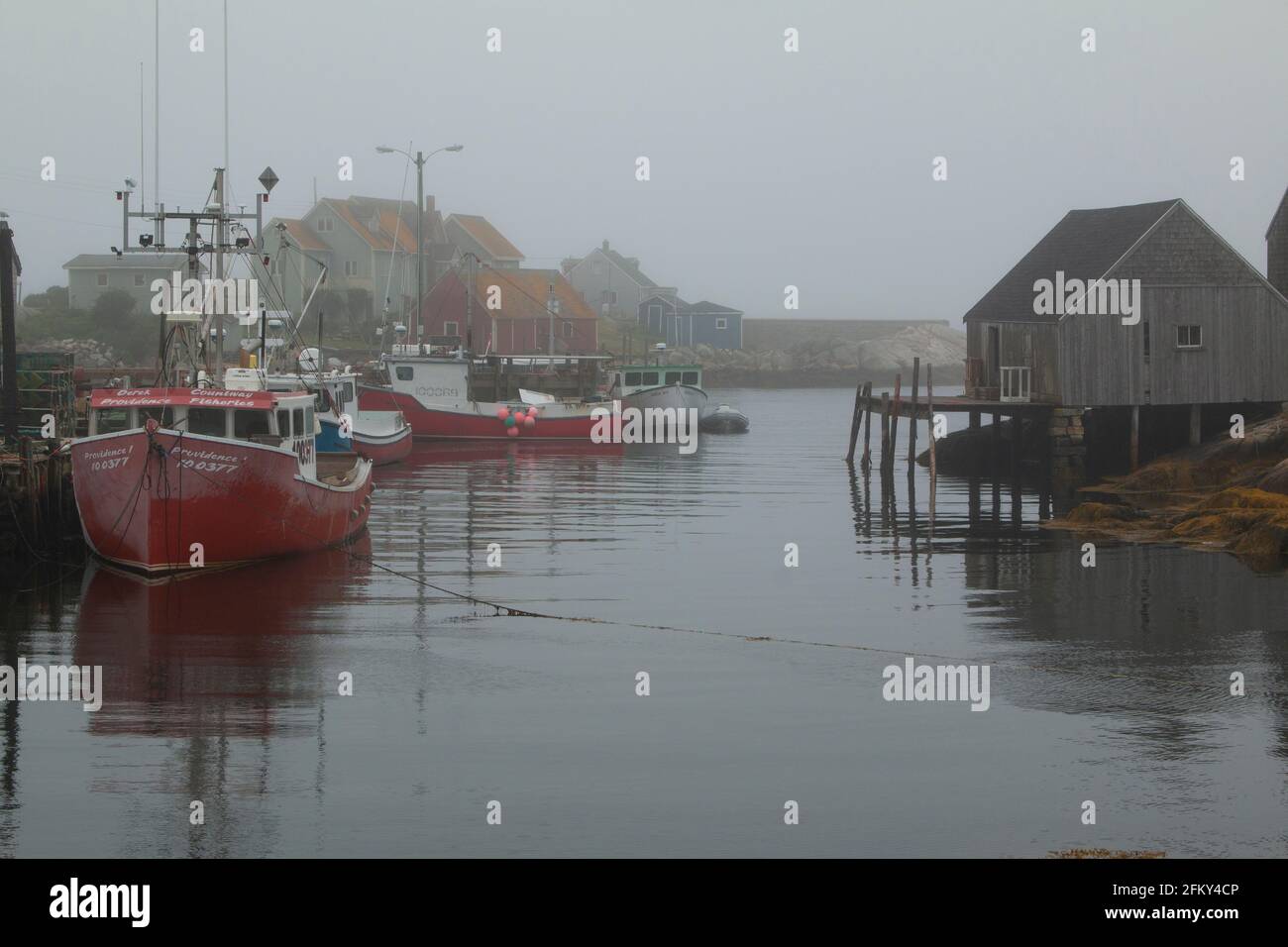 Lobster Boats ormeggiate a Peggy's Cove Harbour, Nova Scotia, Canada, villaggio commerciale di pescatori, nebbia, sito ecoturismo Foto Stock