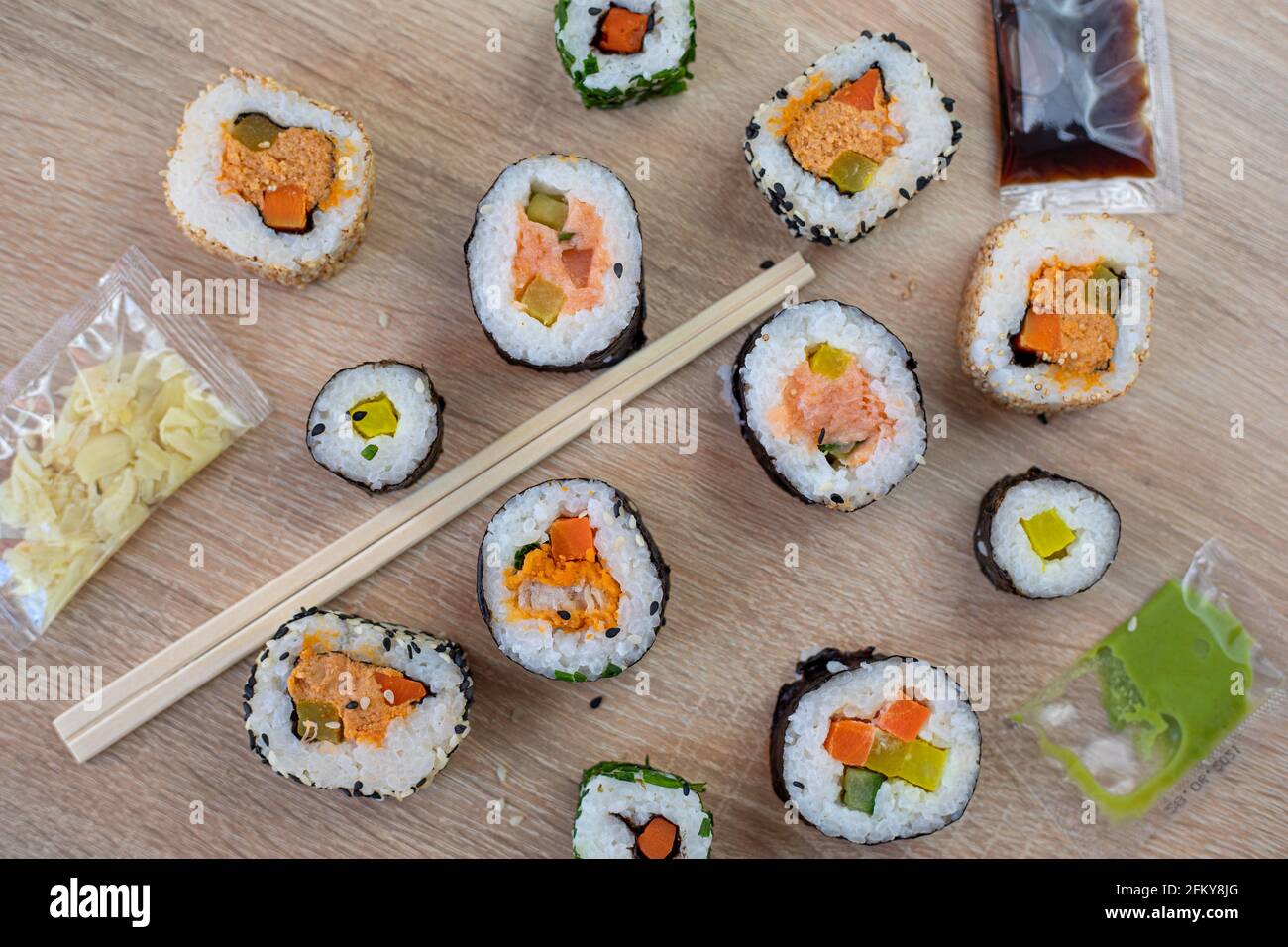 Set di sushi maki con chisses e varie salse sfondo in legno per il menu Foto Stock