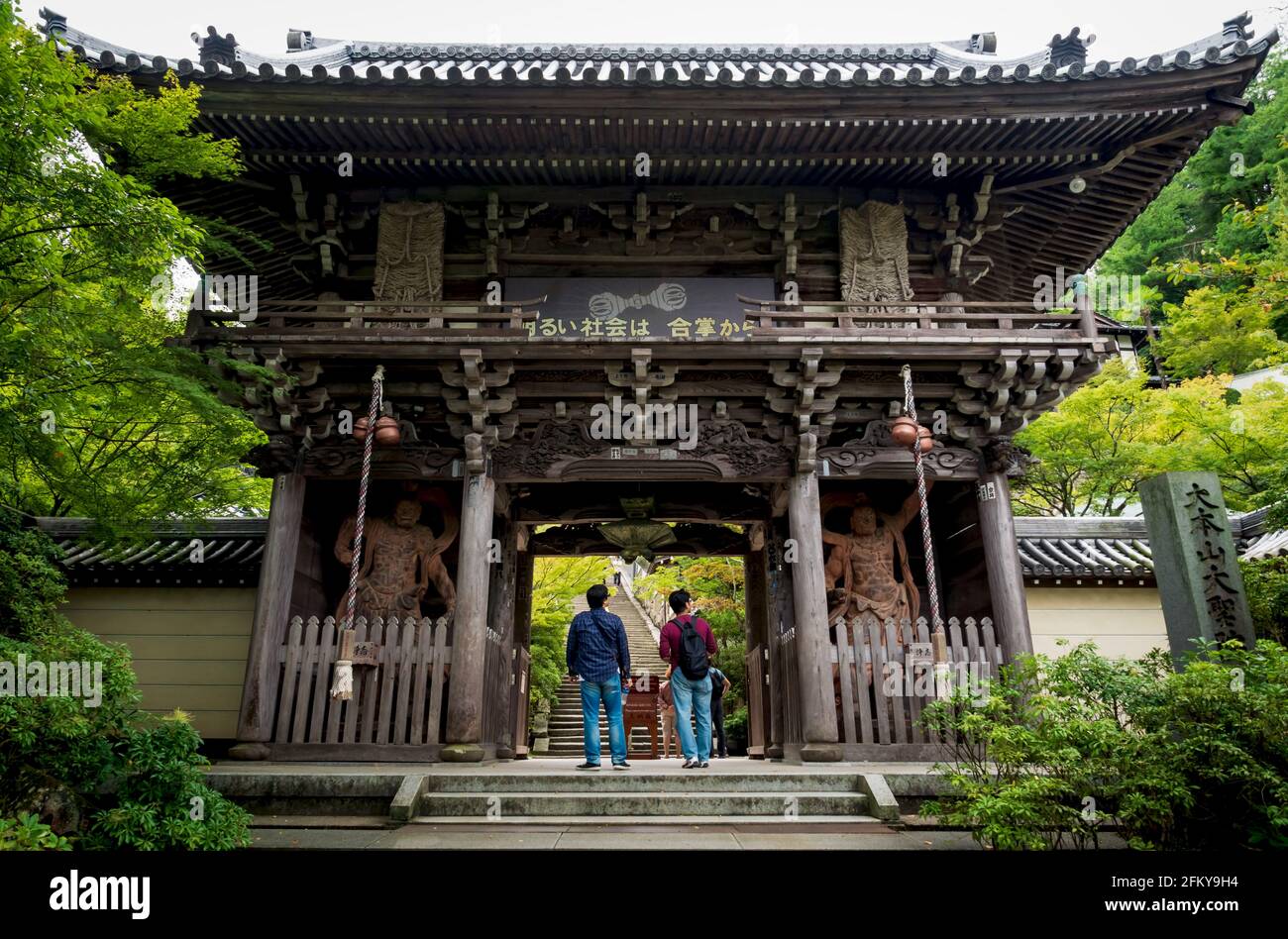 Miyajima, Hiroshima, Giappone - 15 settembre 2017: I visitatori che guardano l'ingresso del cancello con le statue dei re nio come guardie nell'edificio in legno di Daish Foto Stock