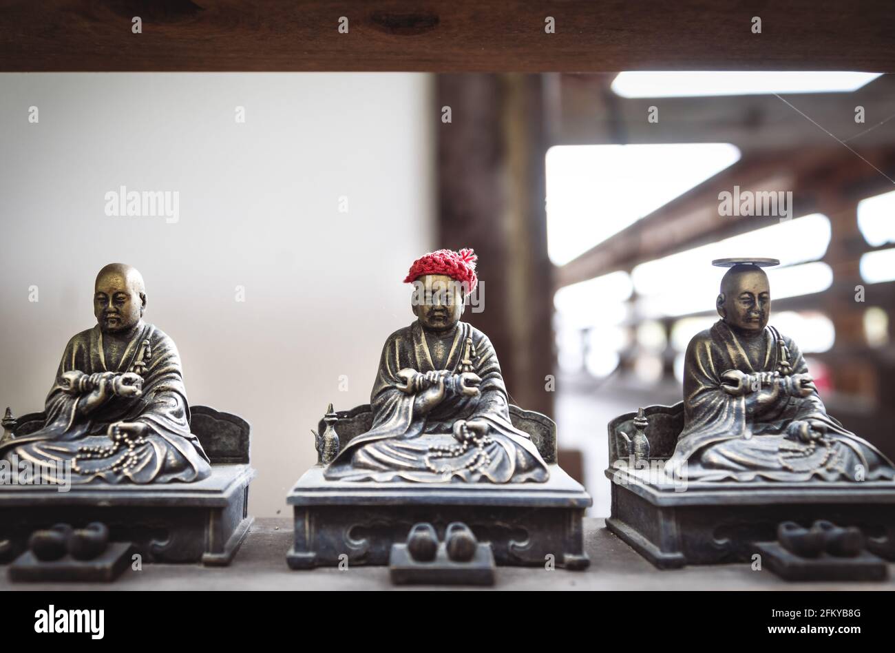 Piccole statue buddhiste in bronzo con offerte di moneta e cappello, che si ritiene di rendere i sogni adoratori si avverano nel tempio di Daisho-in a Miyajima, Hi Foto Stock