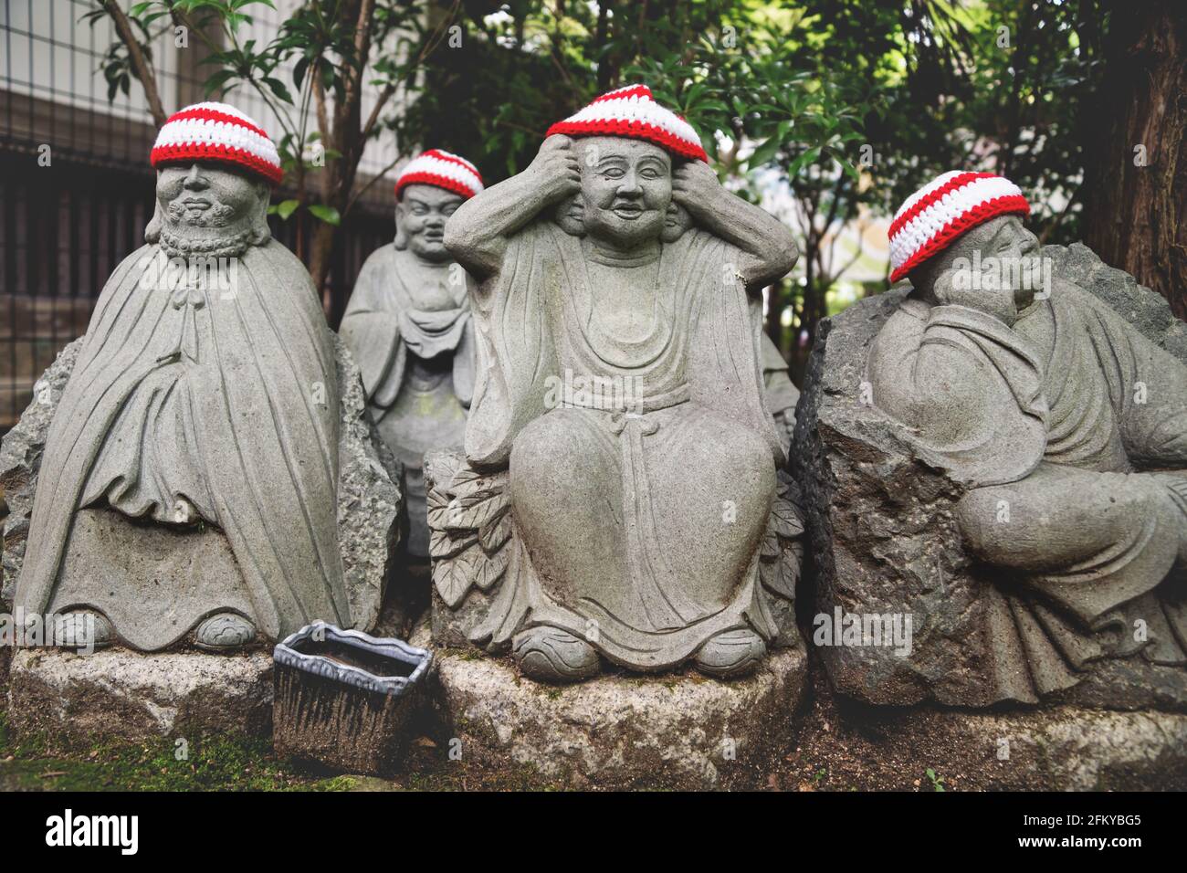 Particolare di statue di Buddha con offerte di cappelli a maglia che rappresentano I primi 500 discepoli dello storico Buddha Shakyamuni al tempio Diasho-in i Foto Stock