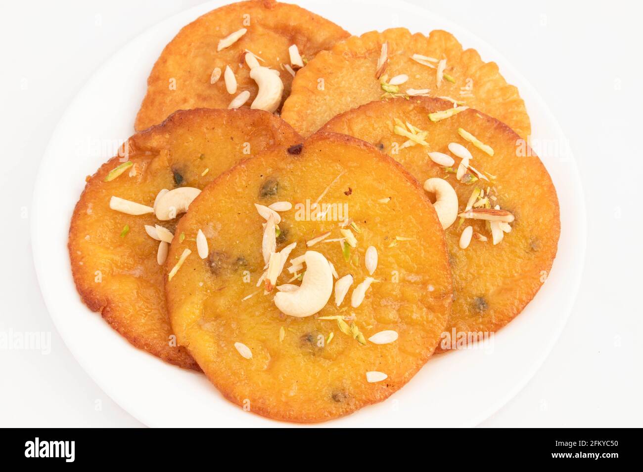 Il delizioso Malpua originario del subcontinente indiano è fatto di grano AATA Maida Semolina Suji fritto profondo in Ghee Shuddha Desi. Decorata con Dry F Foto Stock