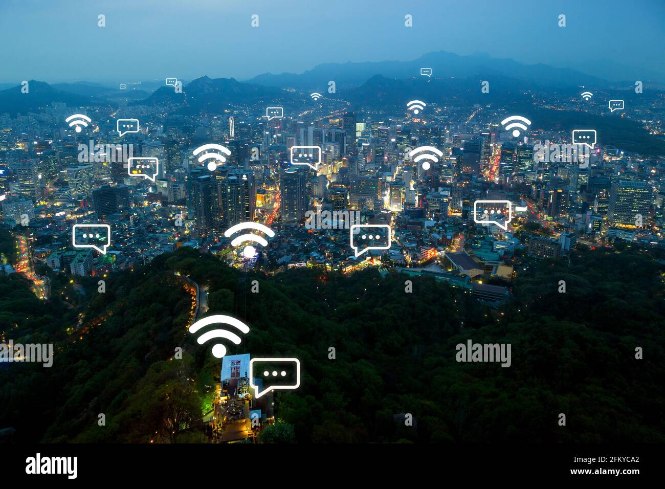 Wi-Fi e icone di messaggi online sullo skyline della città e Namsan Hill a Seoul, Corea del Sud al tramonto. Connessione di rete wireless e concetto di città intelligente. Foto Stock