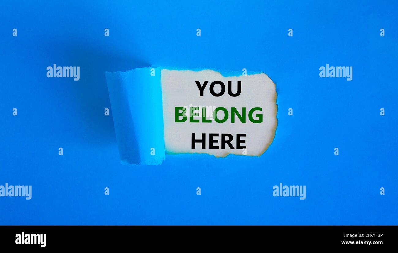Il simbolo dell'utente appartiene qui. Le parole di concetto "sei qui" appaiono dietro la carta blu strappata. Splendido sfondo. Affari e voi appartenete qui, meglio io Foto Stock