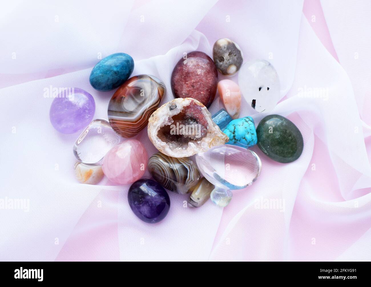 Gemme e cristalli tumbled e ruvidi di vari colori. Ametista, quarzo rosa, agato, apatite, aventurina, olivina, turchese, acquamarina, roccia cr Foto Stock