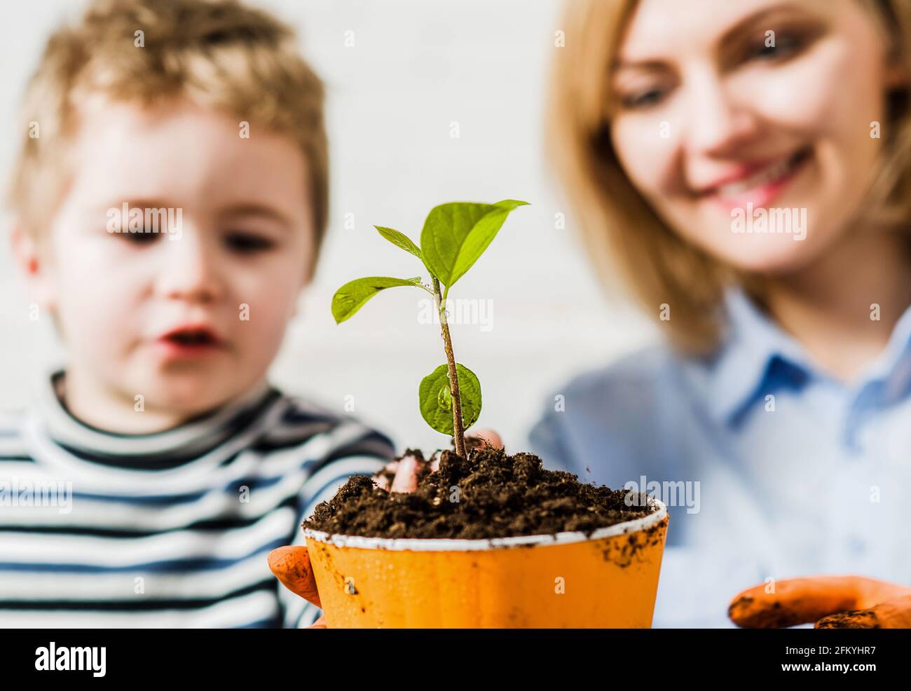 Relazioni familiari. Madre con il figlio piccolo che pianta il fiore. Cura per piante. Giardinaggio scoperta e insegnamento. Foto Stock