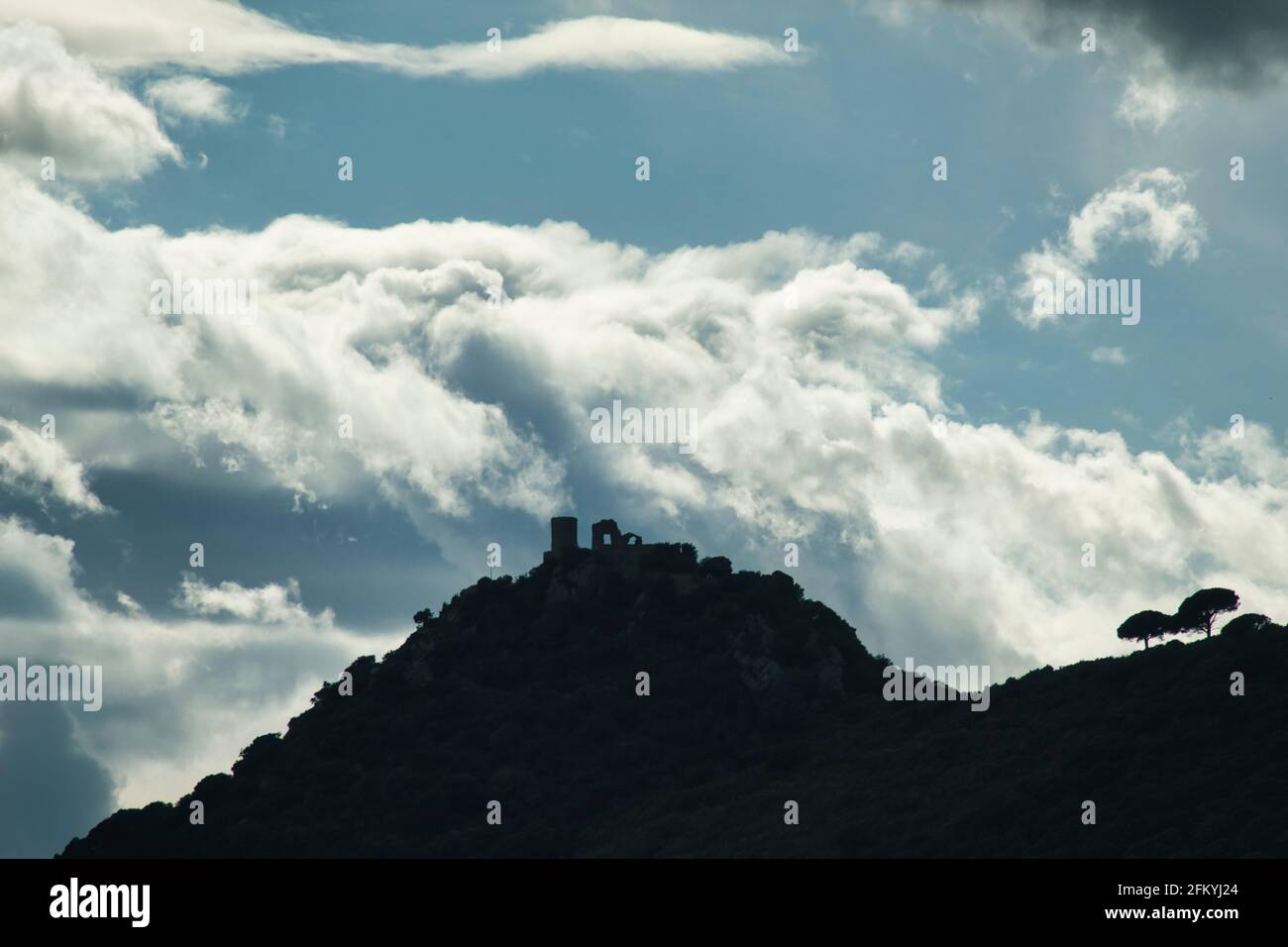profilo di un castello su una montagna con cielo nuvoloso dietro Foto Stock