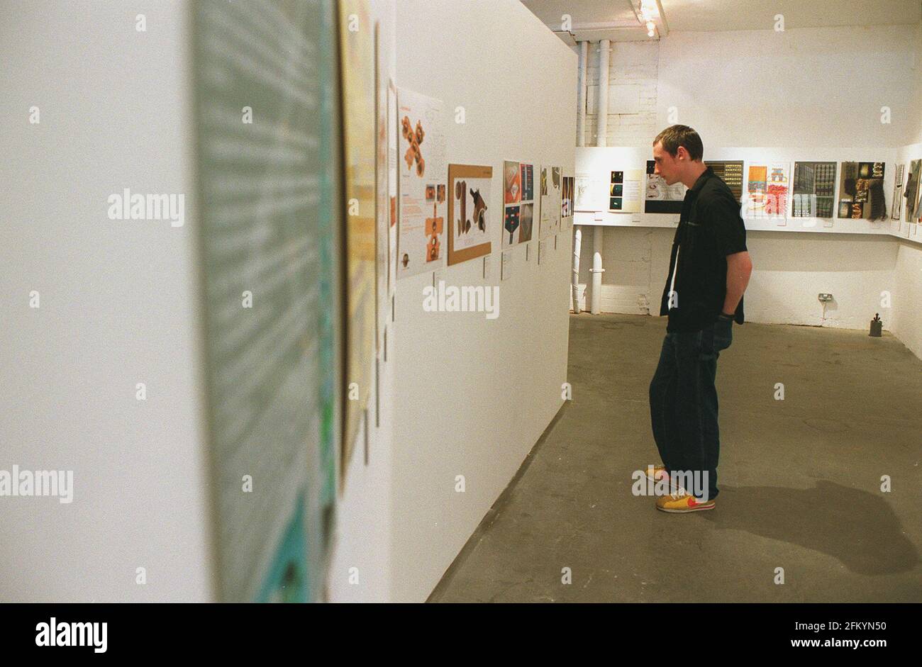 UN VISITATORE DEGLI STUDENTI DESIGN AWARDS IN MATTONE CORSIA ESAMINA ALCUNI DEI LAVORI IN OFFERTA. I PREMI SONO IN COLLABORAZIONE CON L'RSA. (SOCIETÀ REALE PER L'INCORAGGIAMENTO DELLE ARTI.) Foto Stock