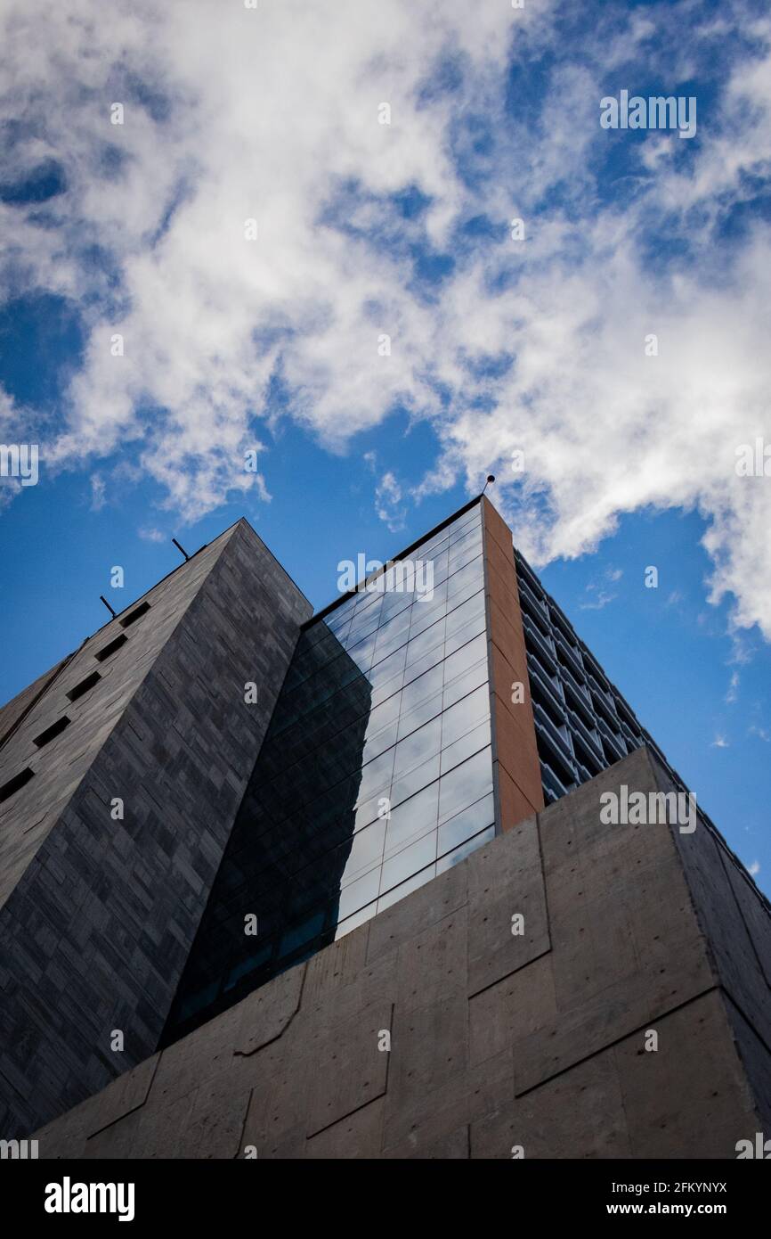Immagine ad angolo basso di un alto edificio su un cielo nuvoloso sfondo Foto Stock