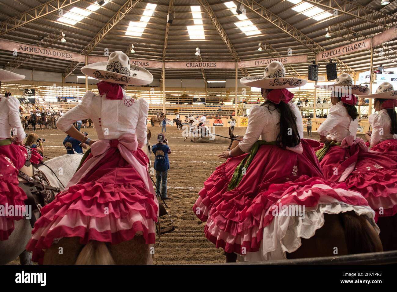 Gli Escaramuzas mettono in mostra le loro notevoli abilità di guida in sella e l'abbigliamento tradizionale al Campeonato Millonario Lienzo de Charro di Jalisco, Messico Foto Stock