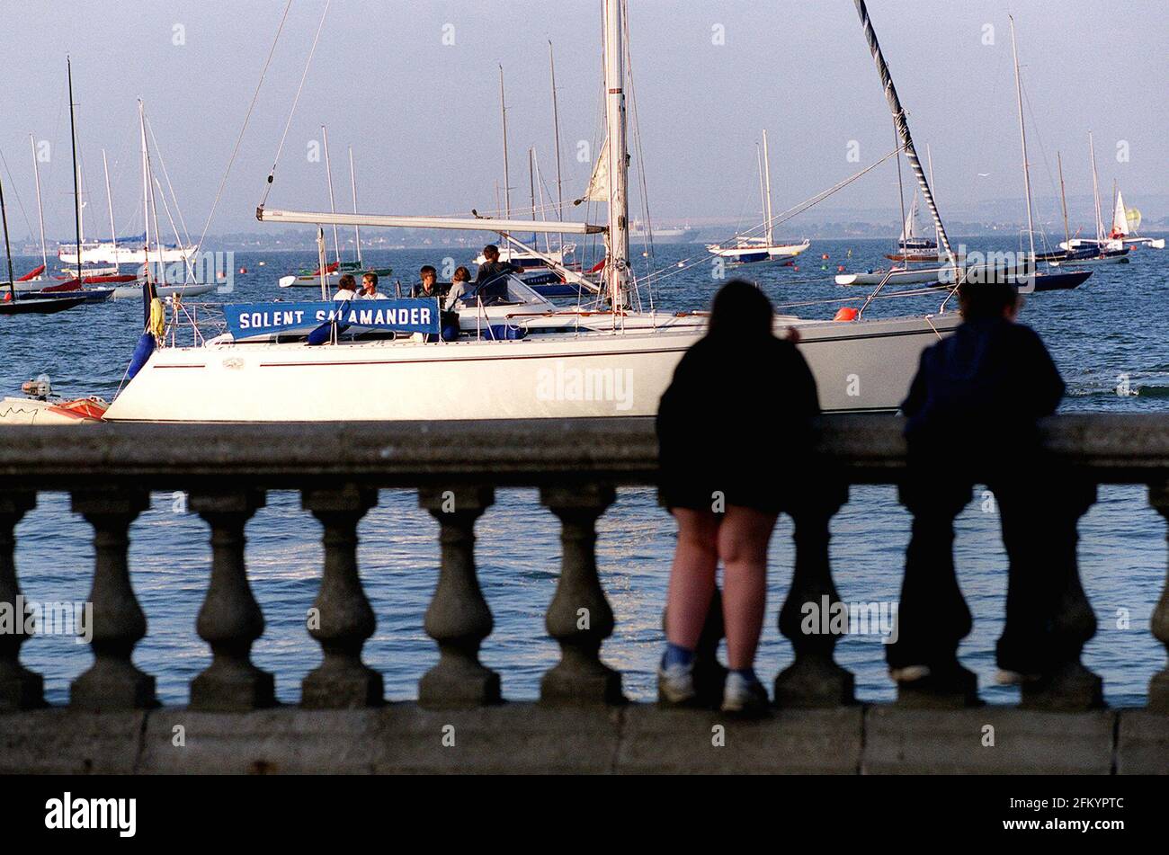 I BAMBINI SULLA PASSEGGIATA A WEST COWES GUARDANO GLI YACHT ARRIVARE ALL'INIZIO DELLA SETTIMANA DI COWES. ISOLA DI WIGHT Foto Stock