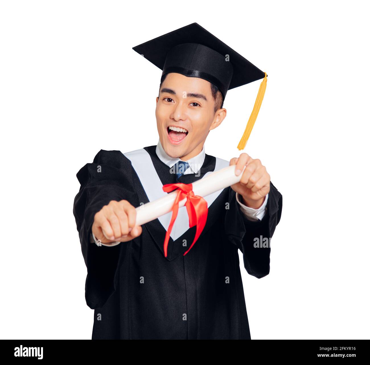 giovane uomo in abito di graduazione nero e cappello che tiene un diploma isolato su sfondo bianco Foto Stock