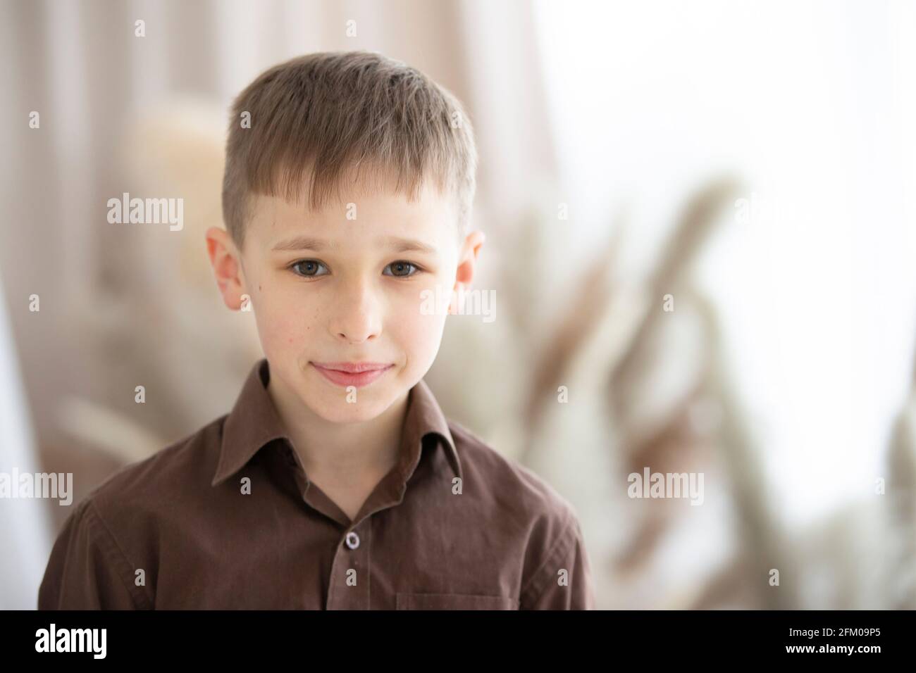 Un ragazzo di nove o dieci anni di aspetto europeo sta guardando la fotocamera. Foto Stock