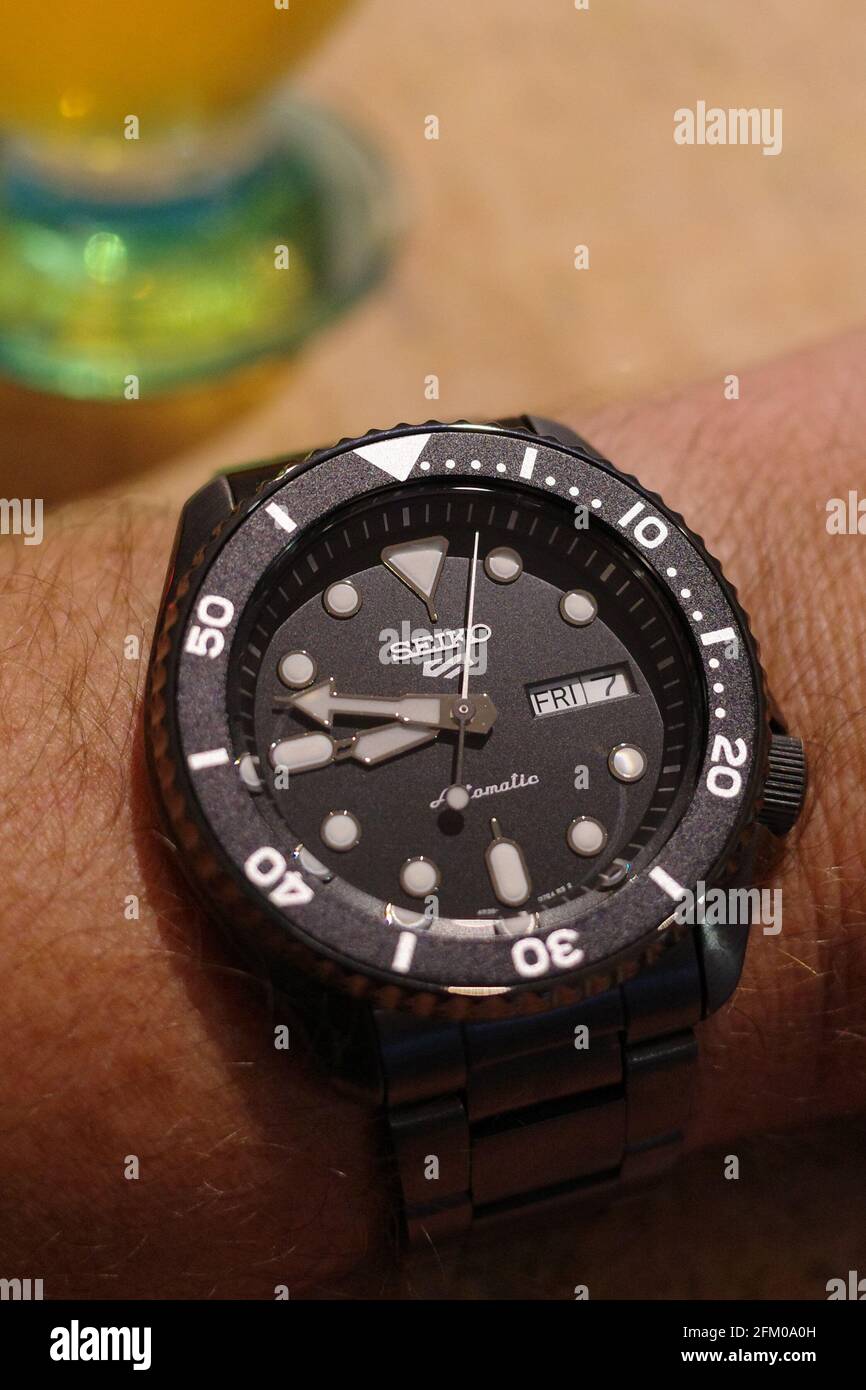 Orologio meccanico automatico Seiko 5 sport subacqueo con quadrante nero, lunetta nera e bracciale nero in acciaio inossidabile spazzolato Foto Stock