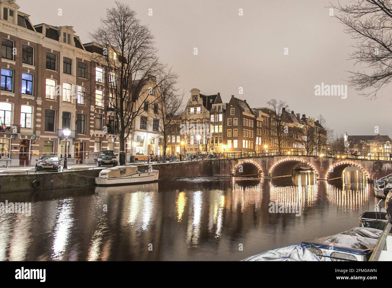 Case tradizionali e ponte lungo il canale illuminato Keizersgracht di notte, Amsterdam, Olanda del Nord, Paesi Bassi Foto Stock