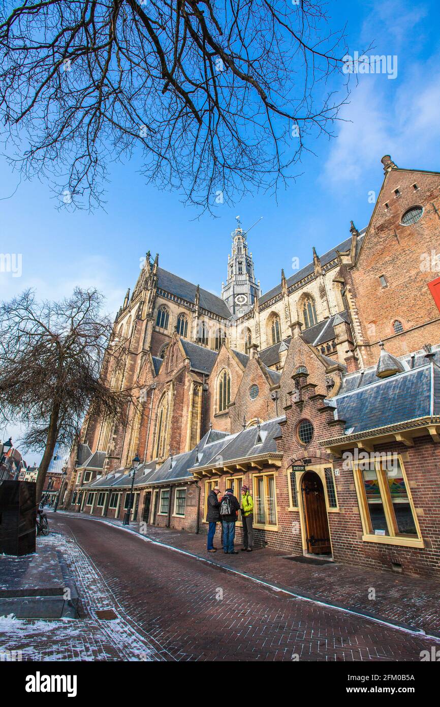 Turisti nel vecchio vicolo di Haarlem con la cattedrale di St.Davokerk sullo sfondo, il quartiere di Amsterdam, l'Olanda del Nord, i Paesi Bassi Foto Stock