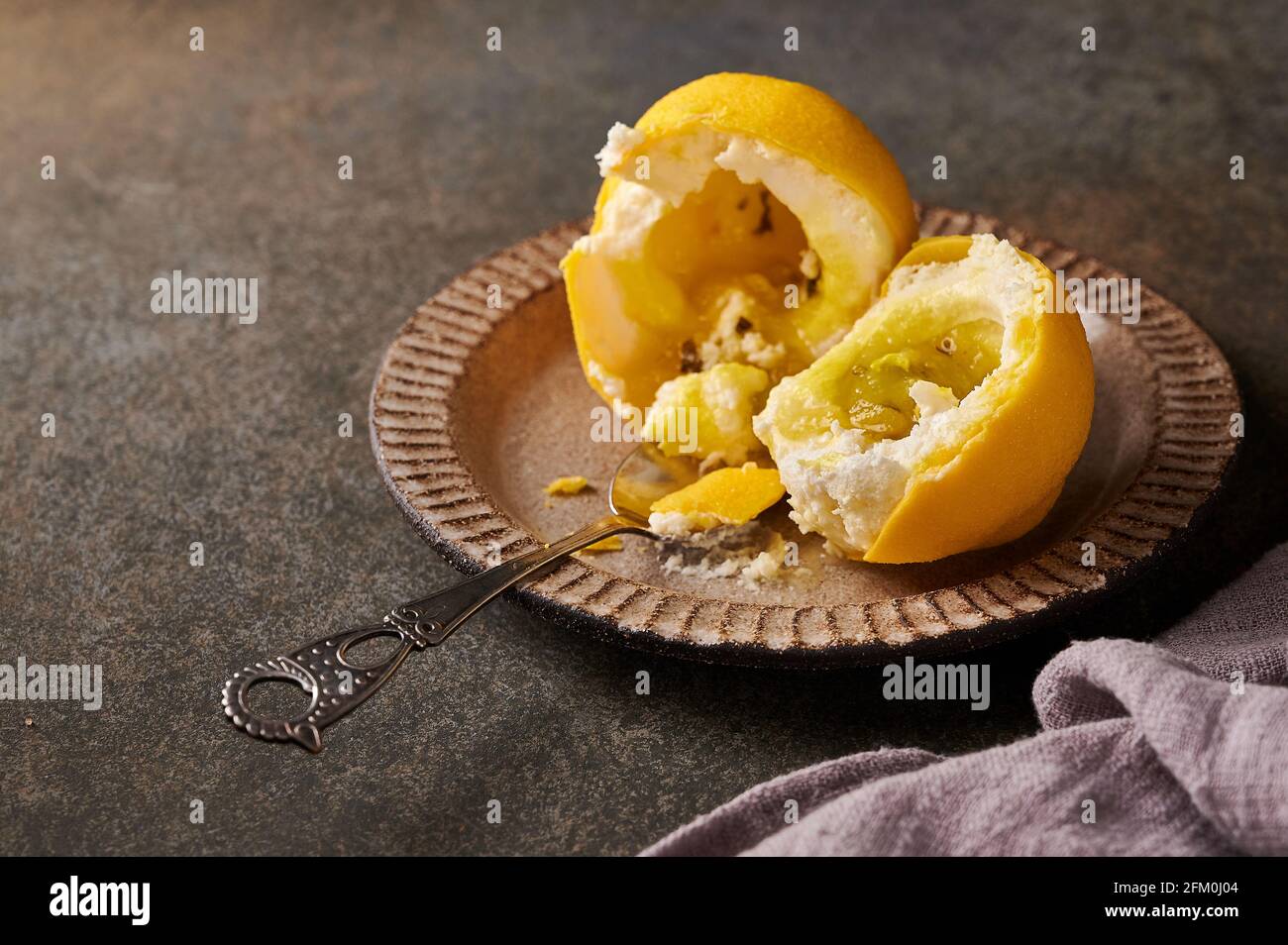 Limone di frutta da dessert originale secondo l'idea di confettiere francesi spezzate a metà - crema a base di mascarpone cremoso con limone in guscio di velluto di cioccolato. Messa a fuoco selettiva Foto Stock