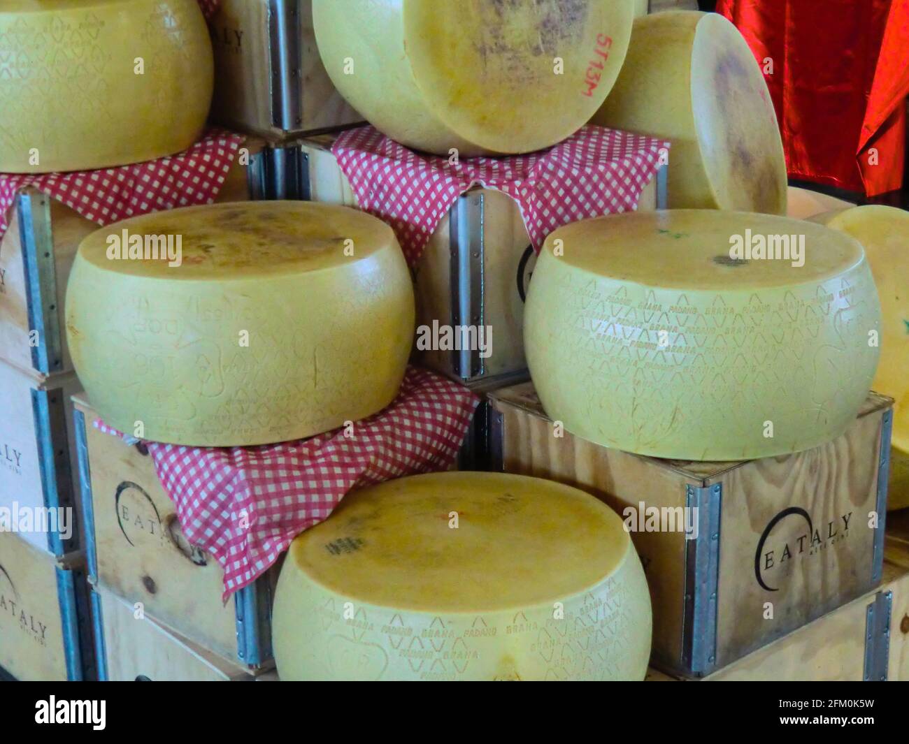 Grandi blocchi di forme italiane di formaggio Grana Padano esposti per la vendita al mercato Eataly a Roma, Italia Foto Stock