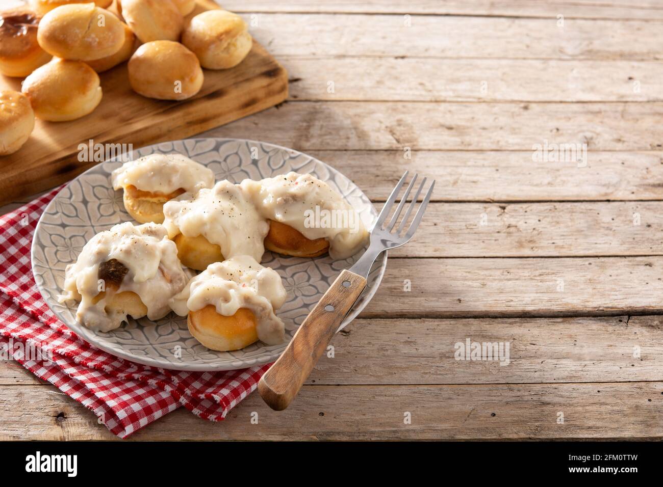 Biscotti americani tradizionali con sugo di carne per colazione su tavolo di legno Foto Stock