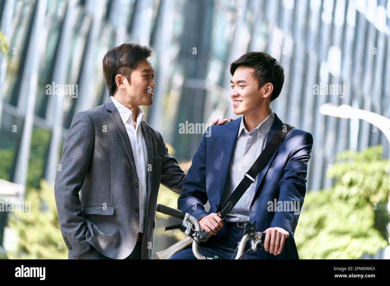 due soci asiatici di affari che hanno una conversazione nel centro di città moderna Foto Stock