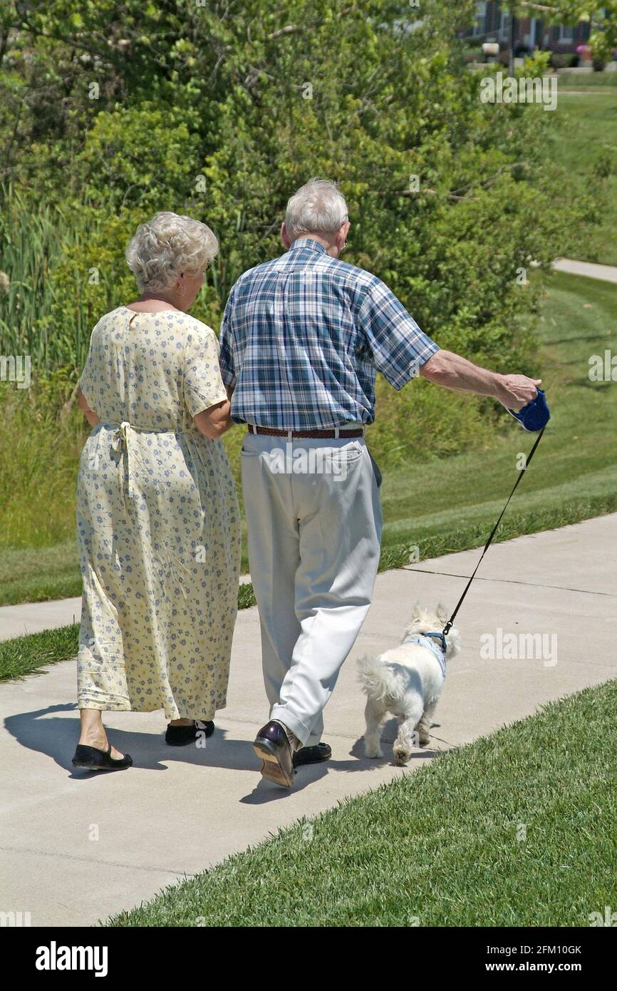 ST. PETERS, STATI UNITI - 30 giu 2006: Una coppia di anziani Wali]lking insieme al loro cane nel parco in Missouri. Foto Stock