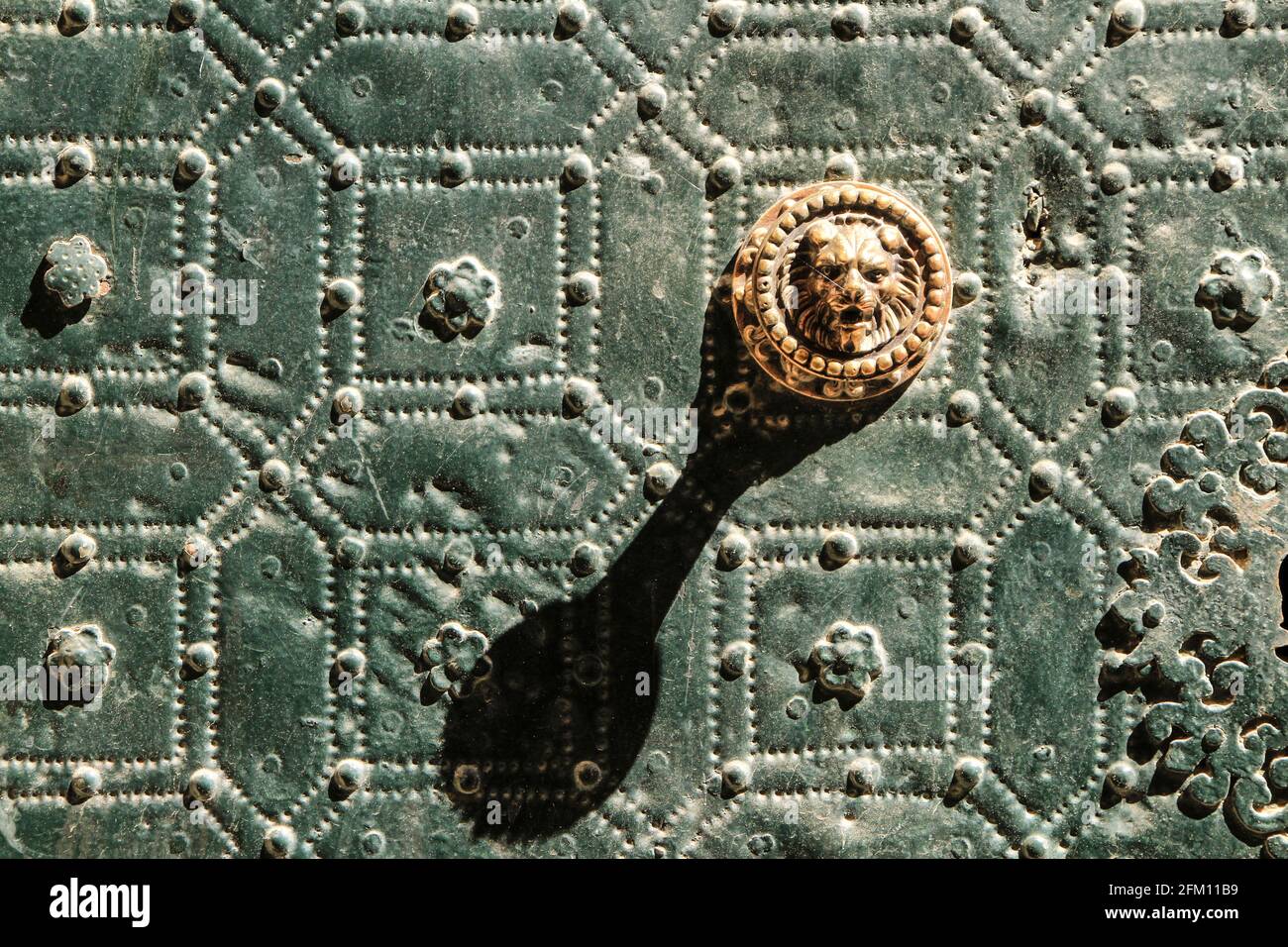 Bella e vintage maniglia porta a forma di leone su metallo verde porta con rifiniture e balaustre Foto Stock