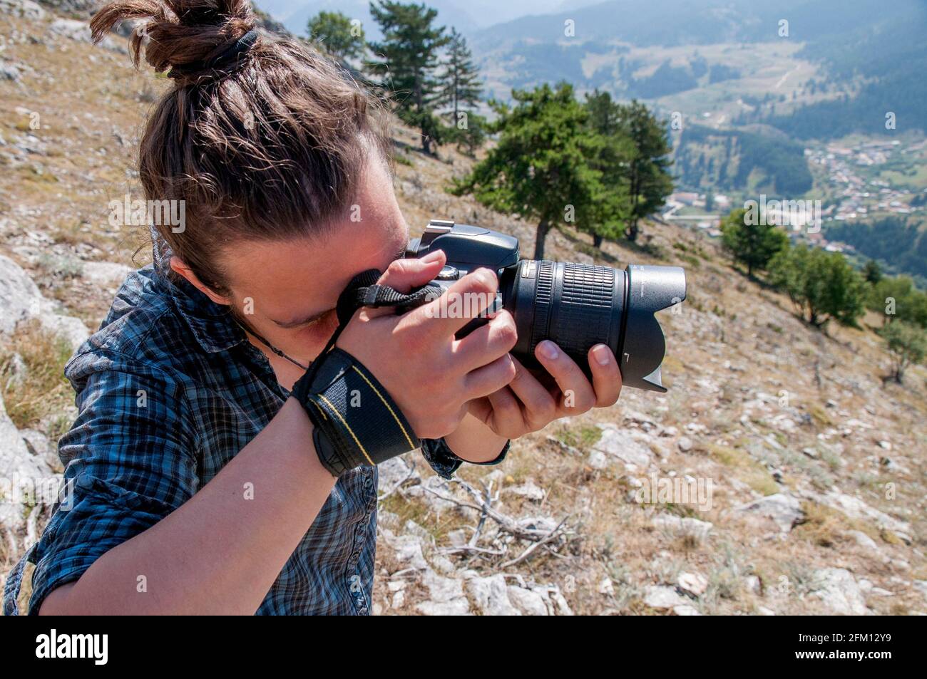 Una giovane donna che scatta una foto su una montagna. Stile di vita blogging / vlogging su vita sana, natura e all'aperto. Foto Stock