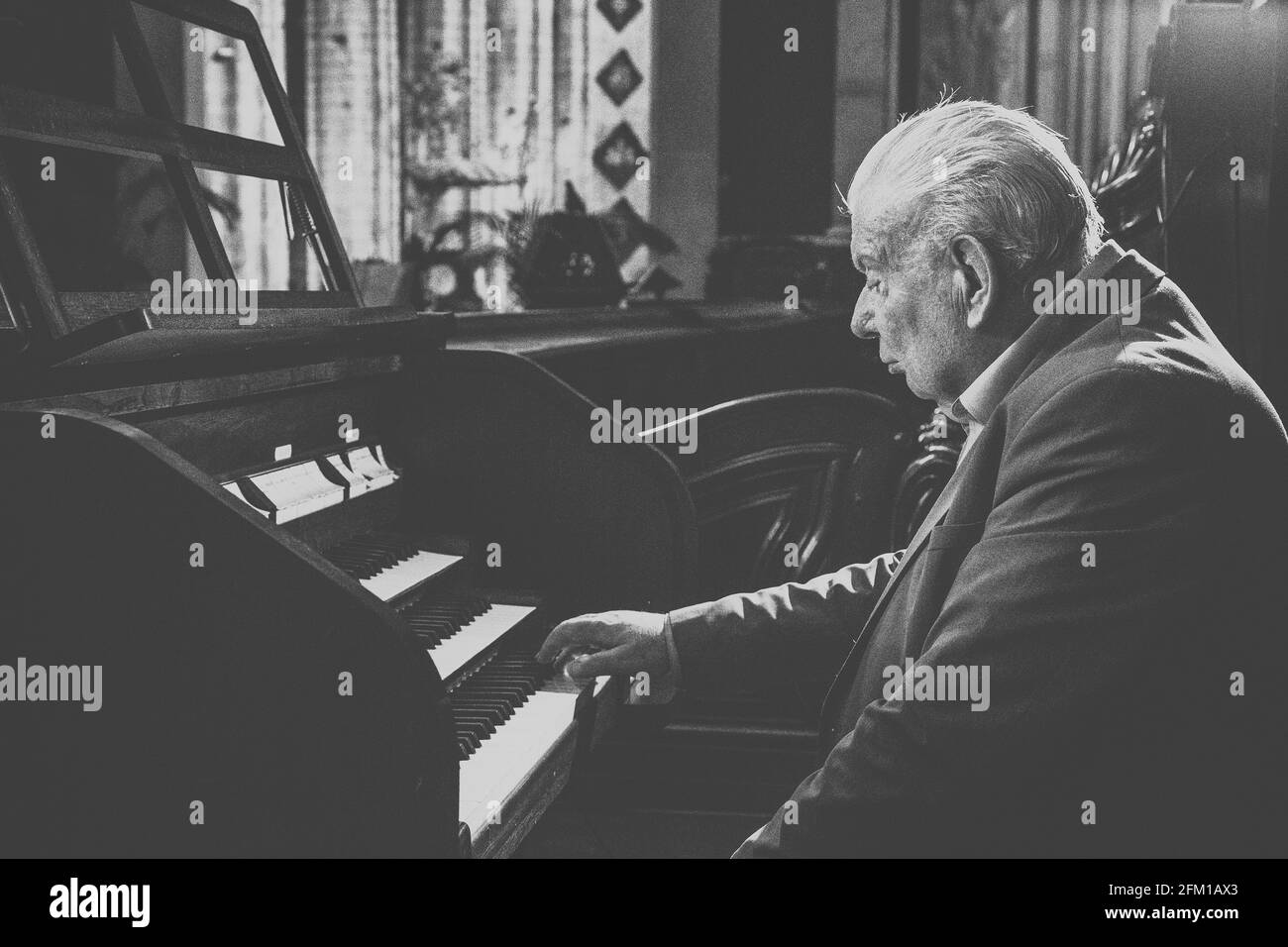 Vecchio uomo che gioca l'organo in Chiesa Foto Stock