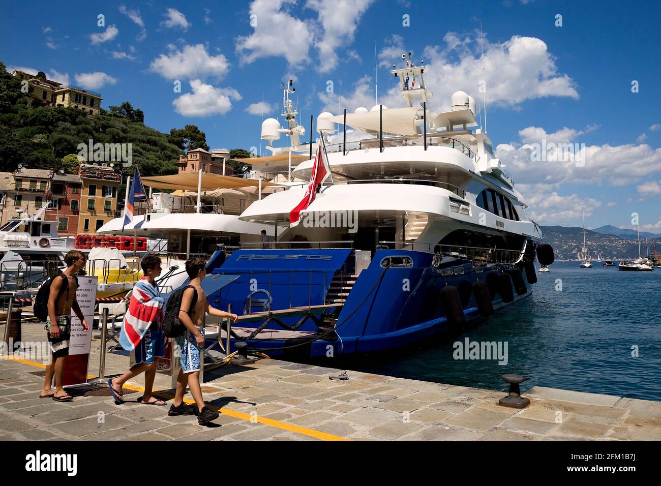 Giovani ragazzi che ammirano i super yacht a Portofino Harbour Foto Stock
