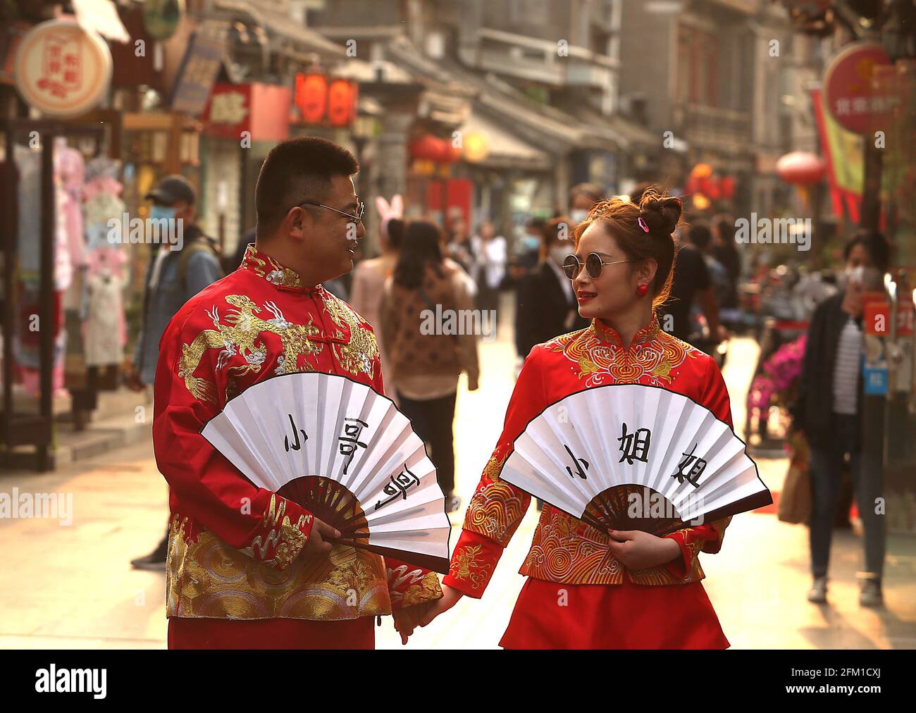 Pechino, Cina. 05 maggio 2021. Sposi cinesi vestiti con abiti da sposa tradizionali posano per le foto in un vecchio vicolo dello shopping a Pechino mercoledì 5 maggio 2021. La Cina ha assistito ad un numero costantemente crescente di divorzi e ad un numero decrescente di matrimoni nell'ultimo decennio, con il rapporto divorzio-a-matrimonio che ha colpito 45 per cento nel 2020, secondo il Ministero degli Affari civili. Più del 73 per cento dei casi di divorzio nel 2017 sono stati portati da donne. Foto di Stephen Shaver/UPI Credit: UPI/Alamy Live News Foto Stock