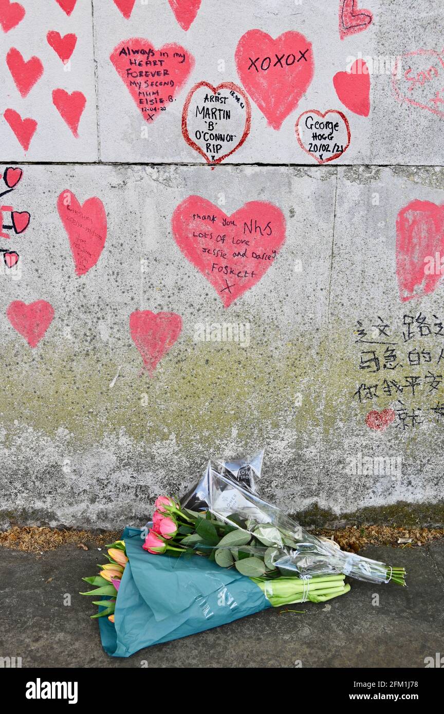Tributi floreali, National COVID Memorial Wall per commemorare le vittime della pandemia COVID-19. South Bank Walkway, Westminster, Londra. REGNO UNITO Foto Stock