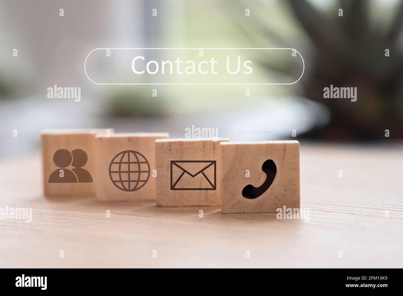 Contattaci icone (telefono, e-mail, posta, persona ) su cubi di legno su sfondo natura. Lavorare a casa durante il coronavirus o il concetto di prevenzione del virus Foto Stock