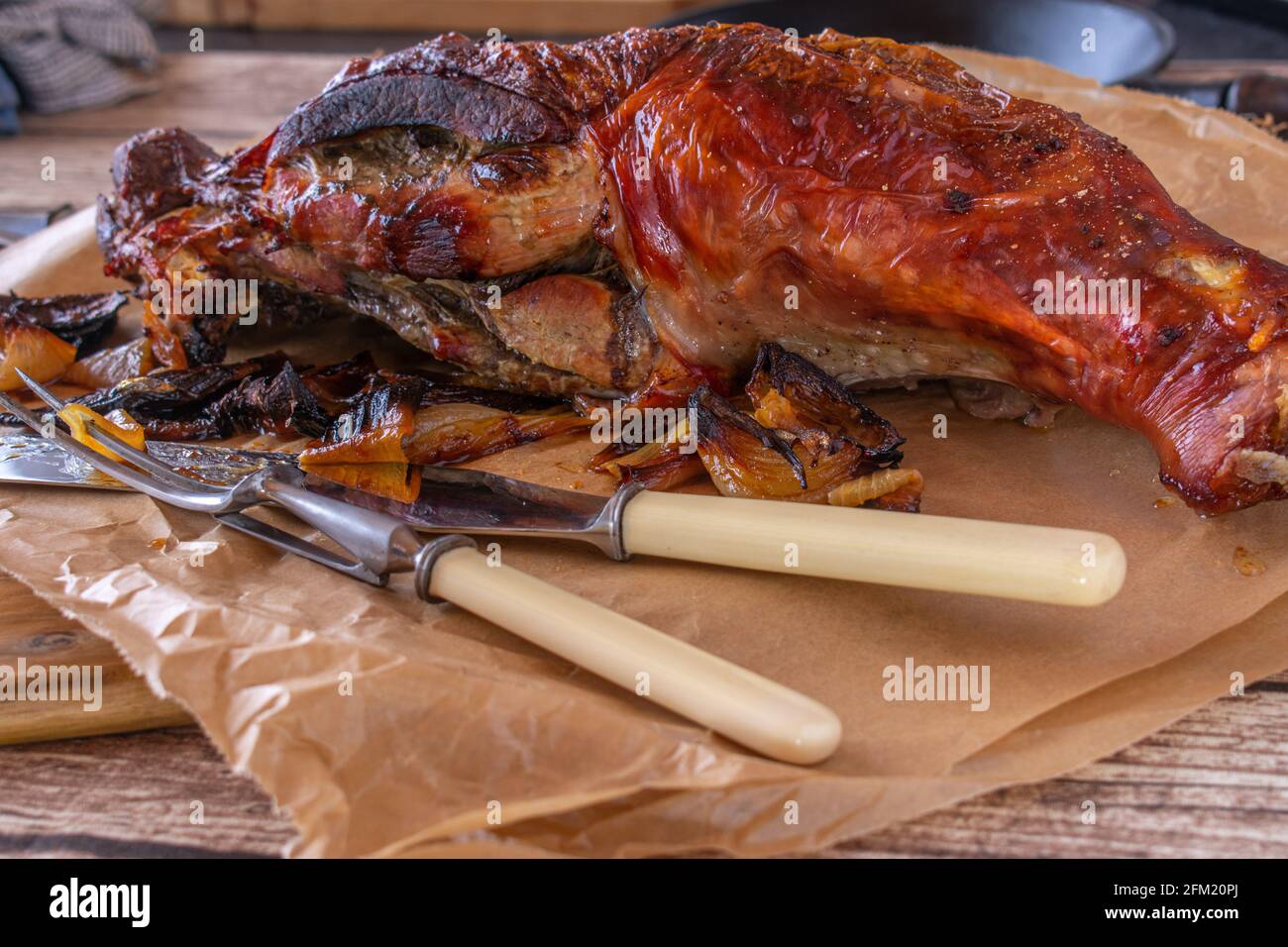 Gamba tacchino grande grigliata su legno rustico tavolo sfondo con posate di intaglio Foto Stock