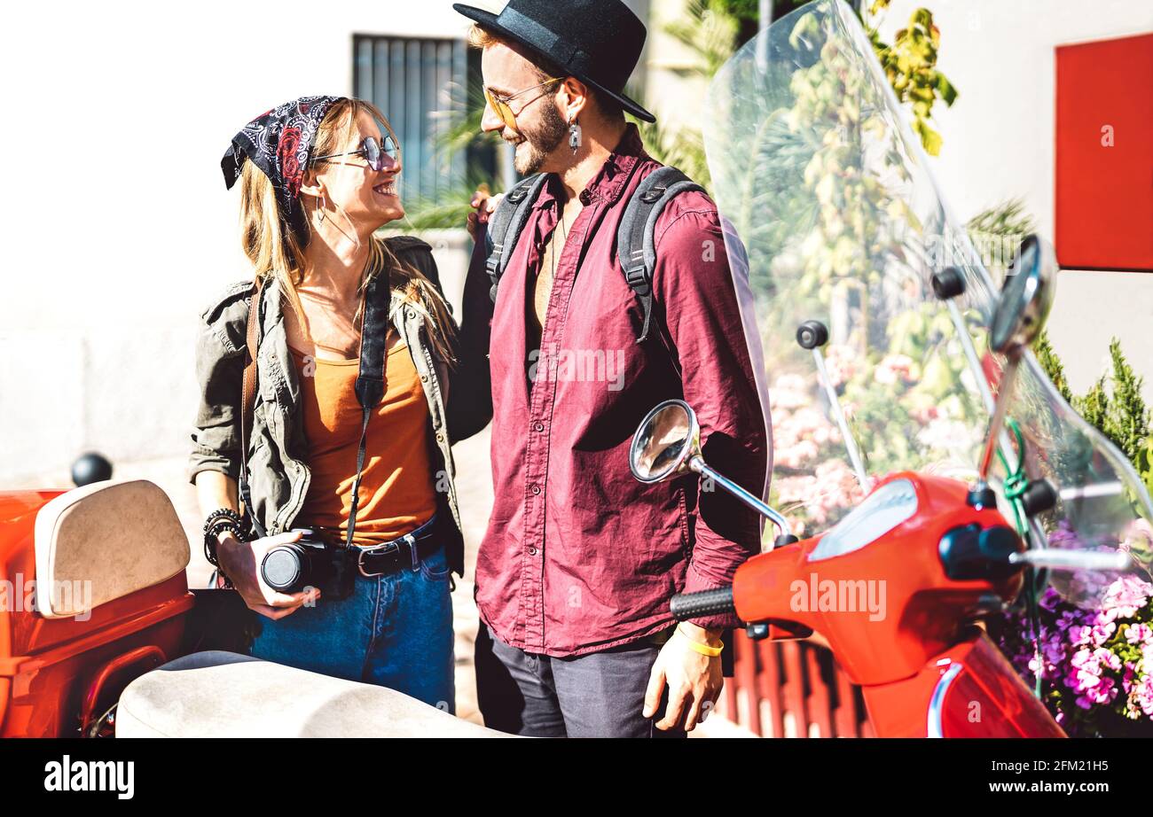 Giovane coppia turistica che si diverte insieme a un giro in scooter ciclomotore - Hipster Guy divertirsi all'aperto con bella ragazza - Buon umore di viaggio e lif Foto Stock