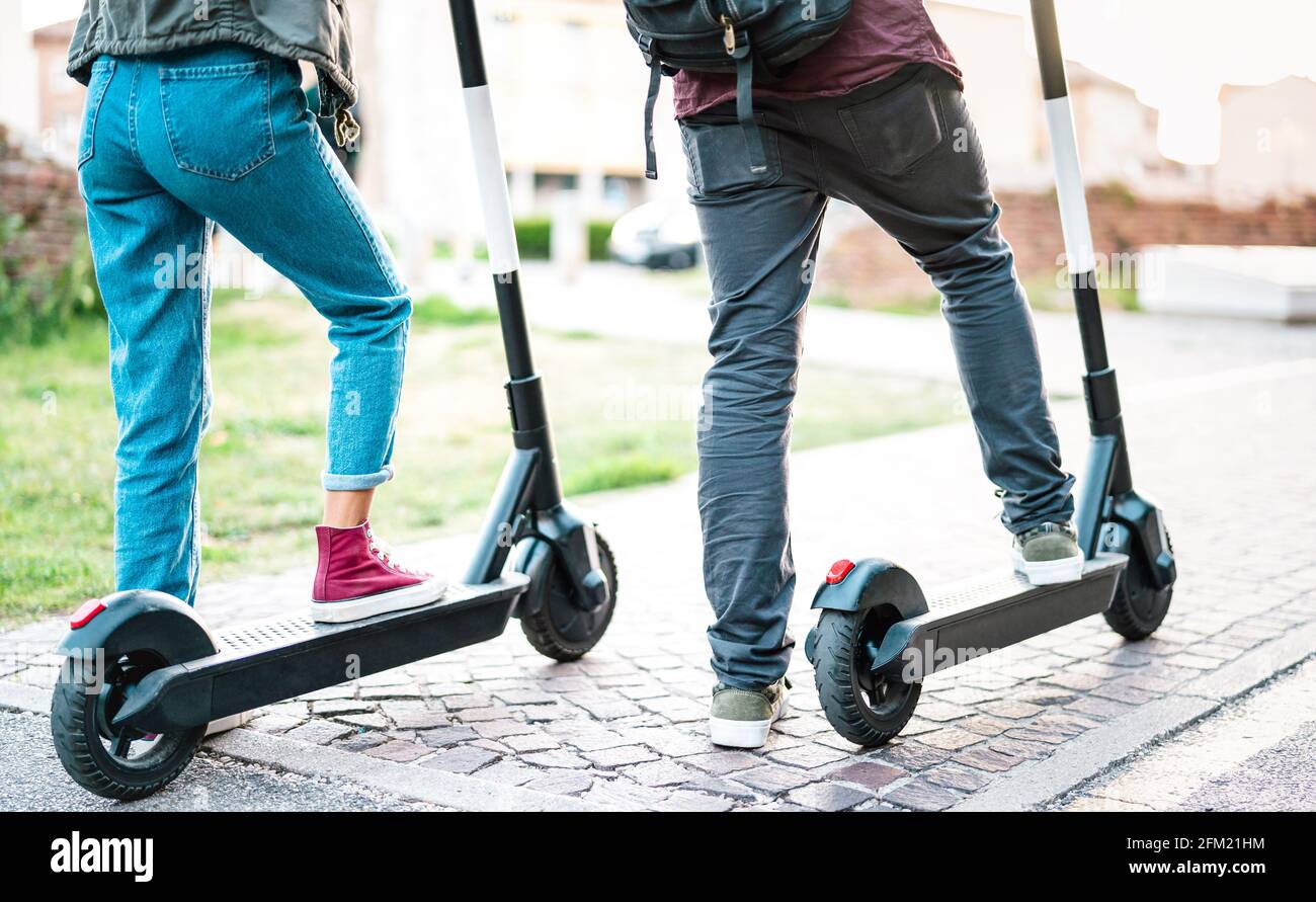 Primo piano di pendolari cittadini che utilizzano scooter elettrico in città park - studenti milleniali che cavalcano un nuovo mezzo ecologico moderno di Trasporti - energia ecologica Foto Stock